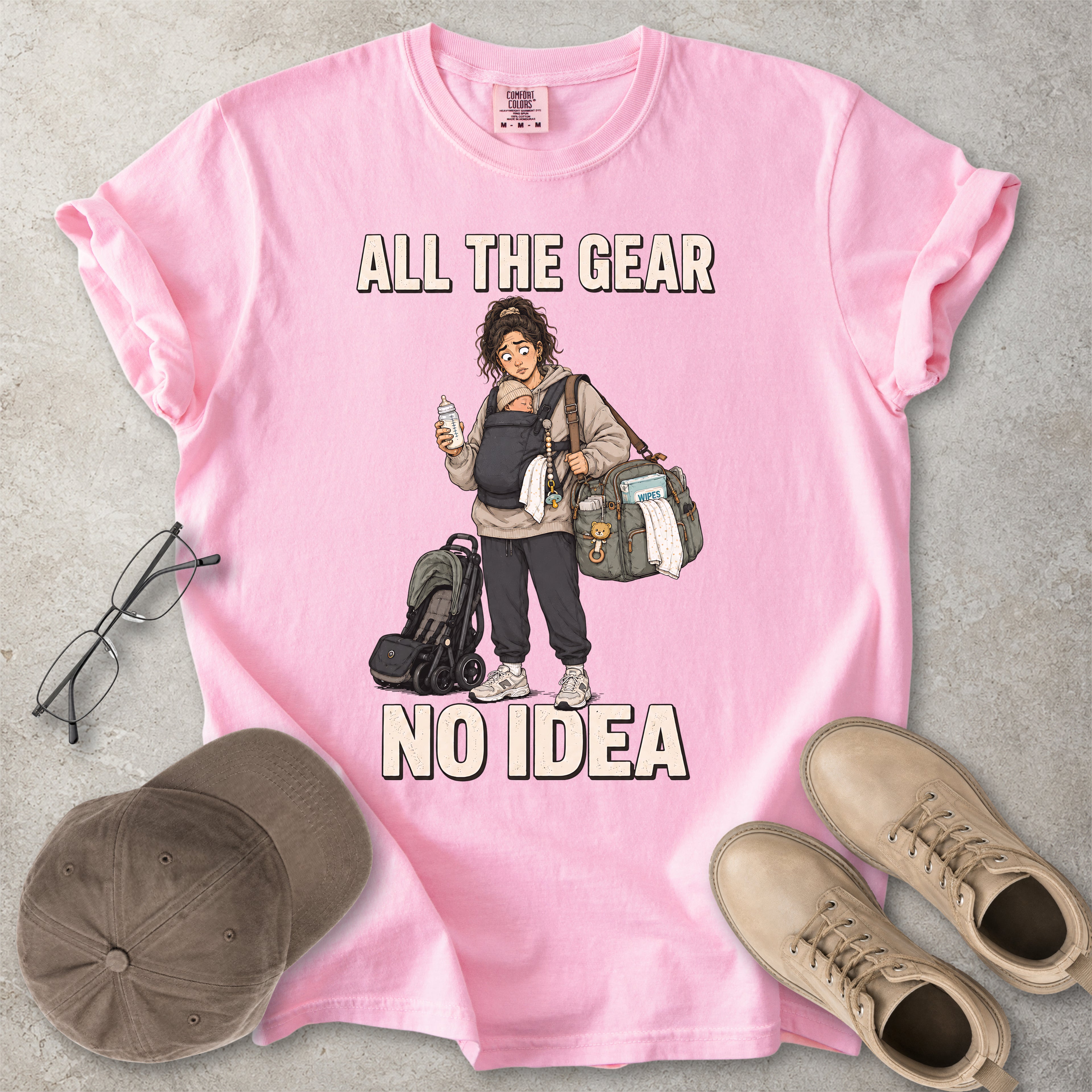 Blossom pink Comfort Colors 1717 T-shirt with a funny All the Gear No Idea new mum graphic showing a tired mother carrying a baby, bottle, changing bag and stroller.