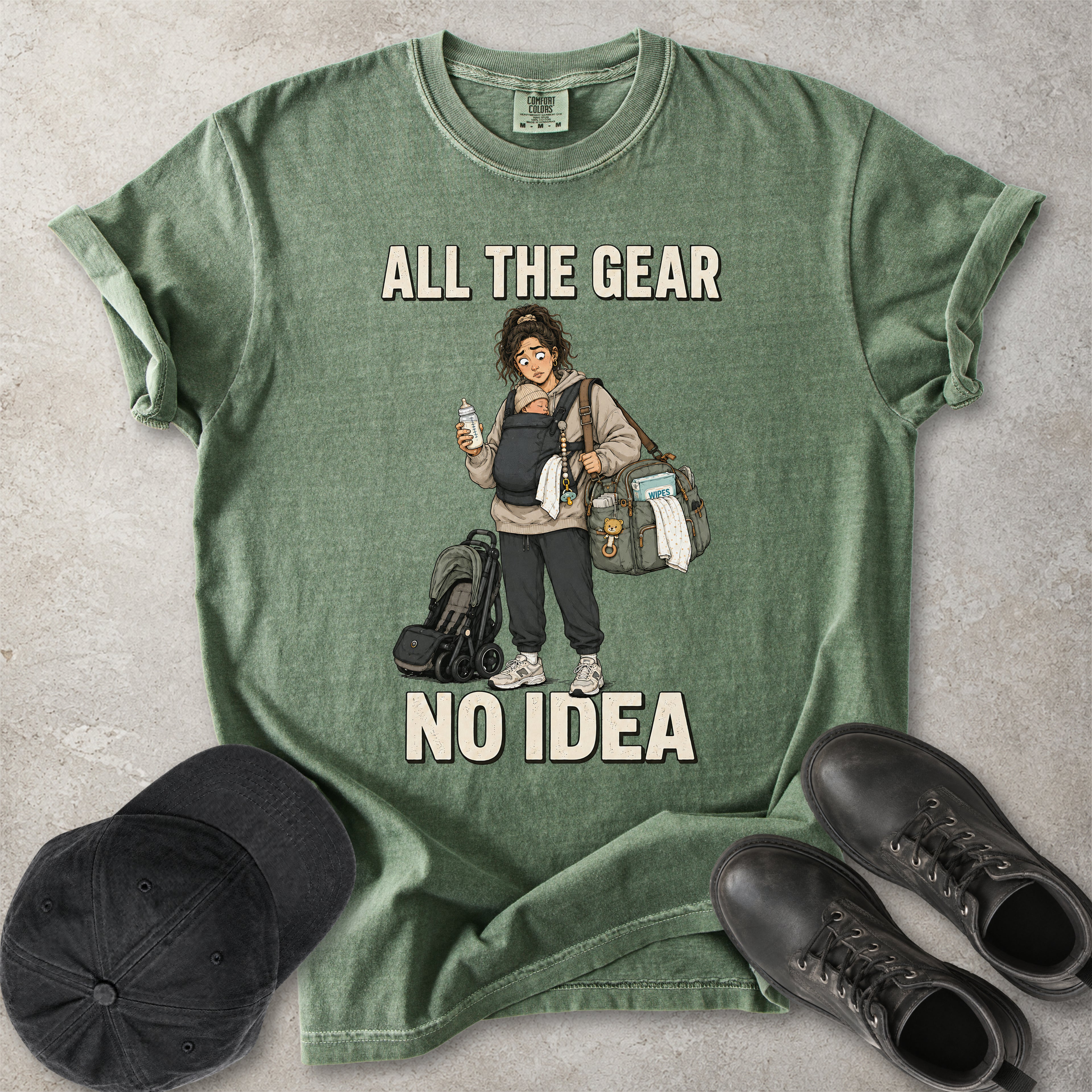 Moss green Comfort Colors 1717 T-shirt with a funny All the Gear No Idea new mum graphic showing a tired mother carrying a baby, bottle, changing bag and stroller.