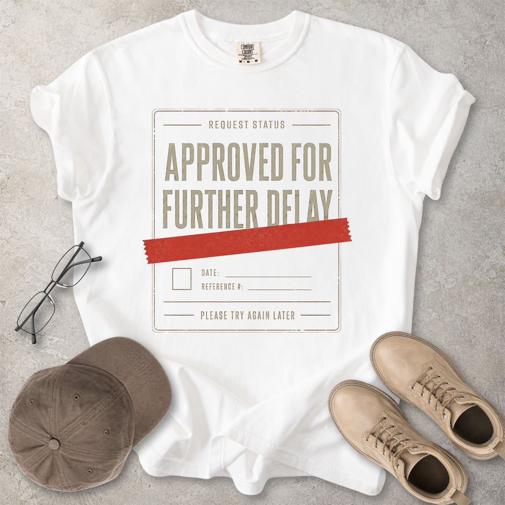 White Comfort Colors 1717 T-shirt with a funny Approved for Further Delay graphic showing a request status form covered with red tape.