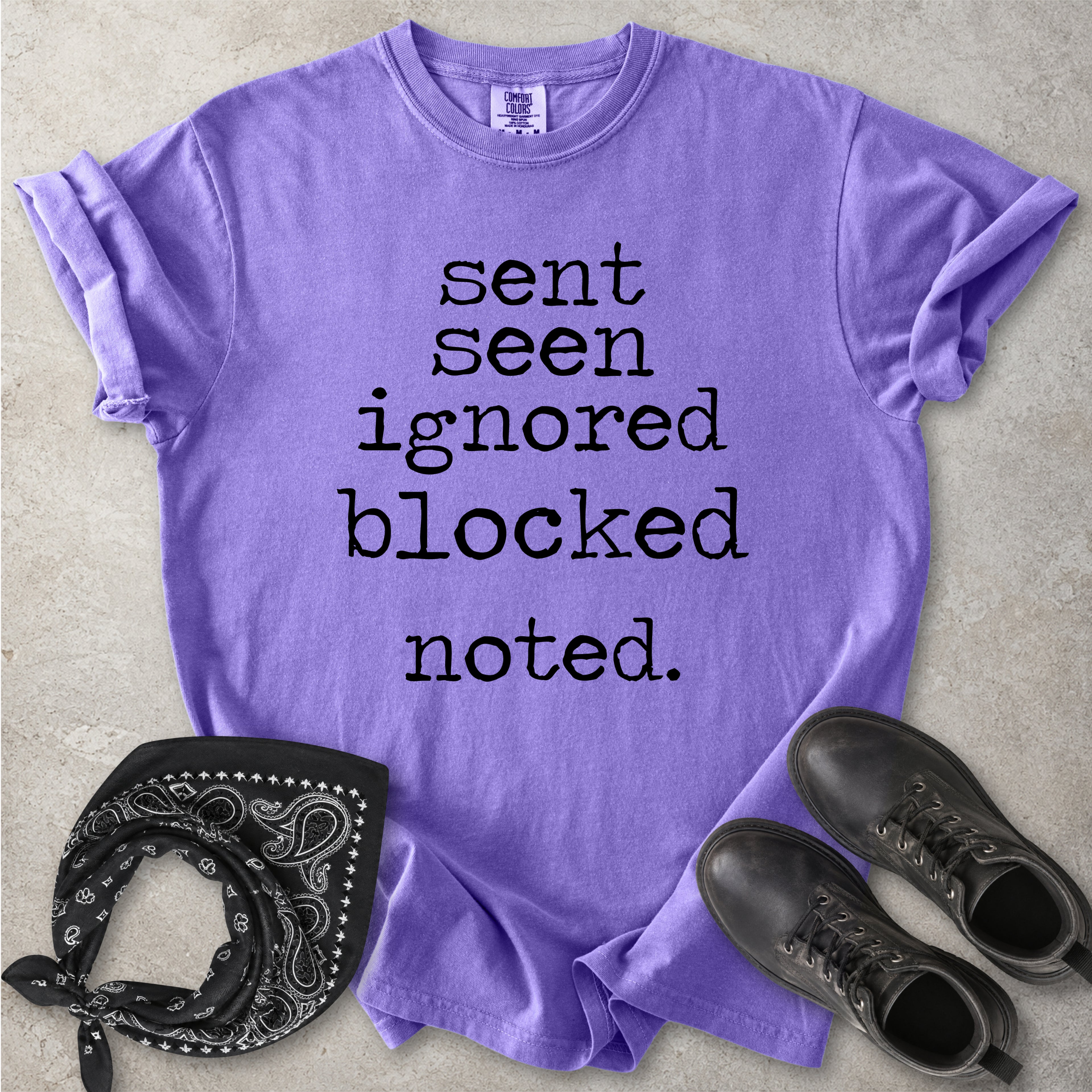 Violet purple Comfort Colors graphic T-shirt with black text reading sent seen ignored blocked noted, styled with black boots and a black bandana