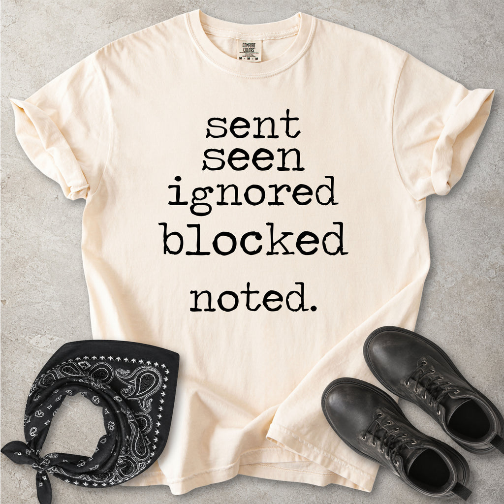 Ivory beige Comfort Colors graphic T-shirt with black text reading sent seen ignored blocked noted, styled with black boots and a black bandana
