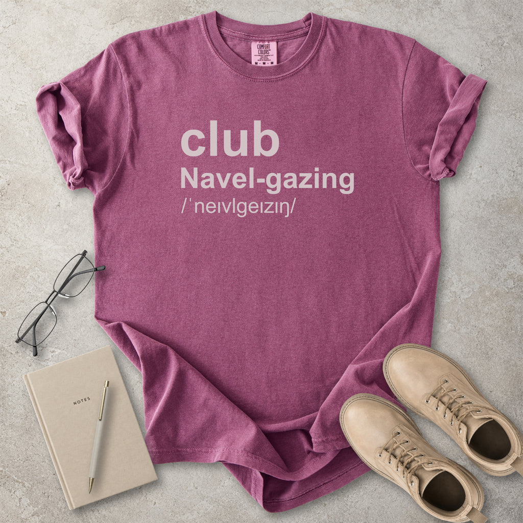 Berry red Comfort Colors graphic T-shirt with grey text reading club navel-gazing, styled with notebook, pen, glasses and tan boots