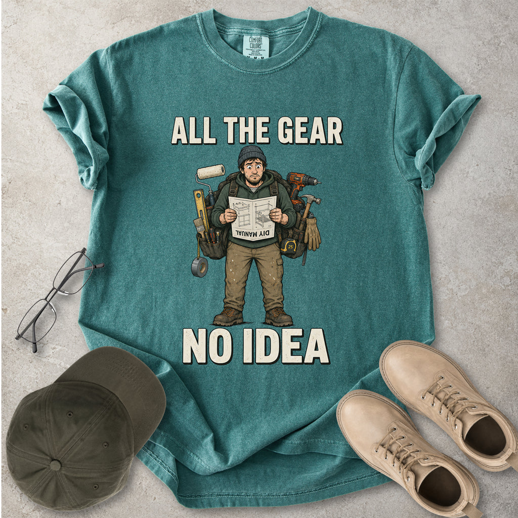 Green blue spruce Comfort Colors 1717 T-shirt with a funny All the Gear No Idea DIY graphic showing a confused handyman carrying tools and reading a manual.