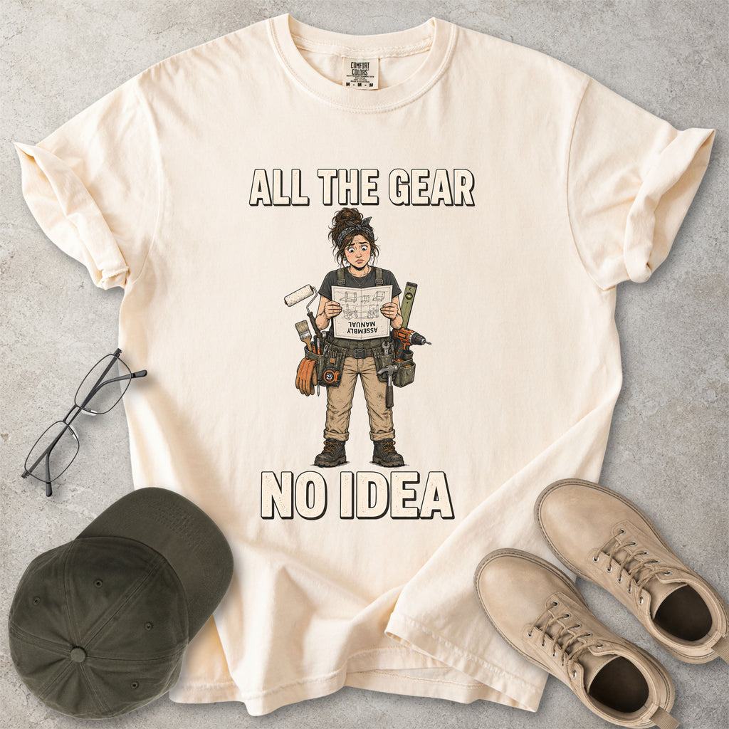 Ivory beige Comfort Colors 1717 T-shirt with a funny All the Gear No Idea DIY graphic showing a woman with tools holding an upside-down assembly manual.