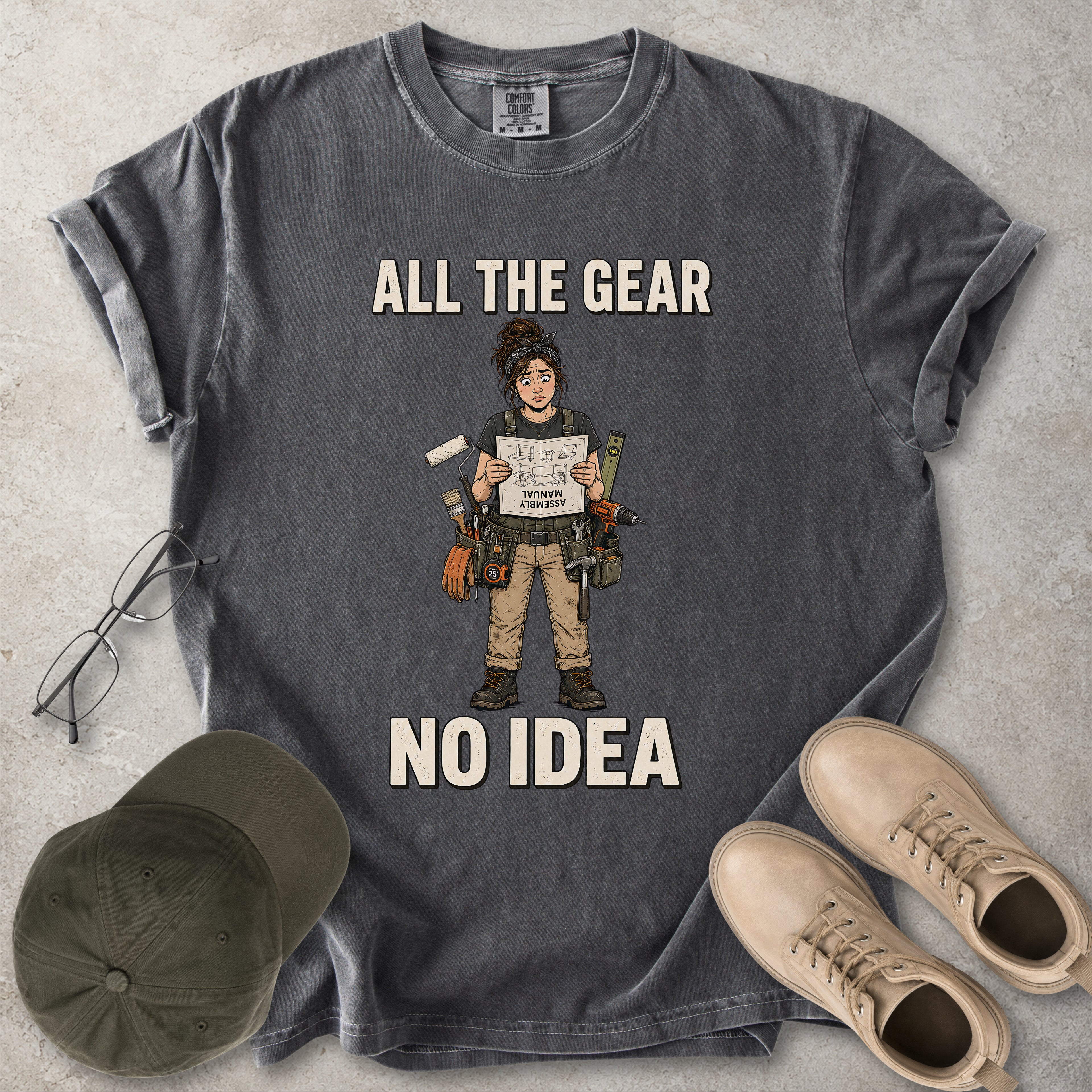 Pepper grey Comfort Colors 1717 T-shirt with a funny All the Gear No Idea DIY graphic showing a woman with tools holding an upside-down assembly manual.