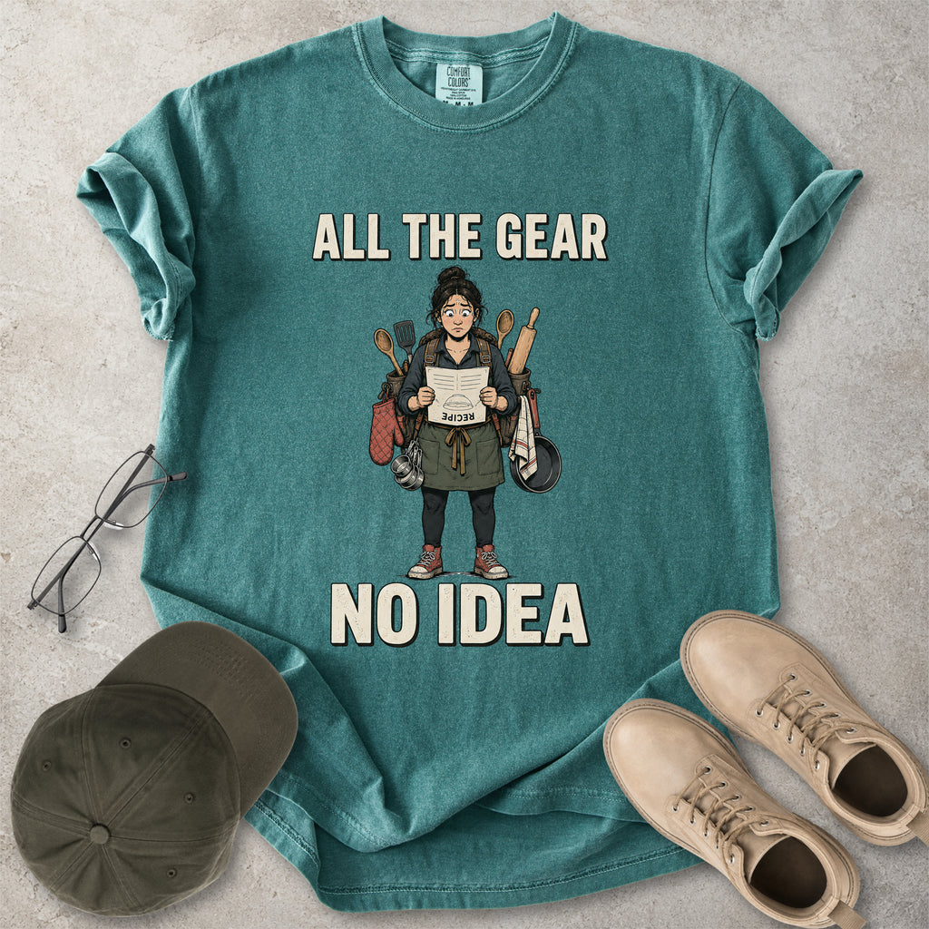 Blue spruce Comfort Colors 1717 T-shirt with a funny All the Gear No Idea cooking graphic showing a woman holding an upside-down recipe with kitchen utensils.