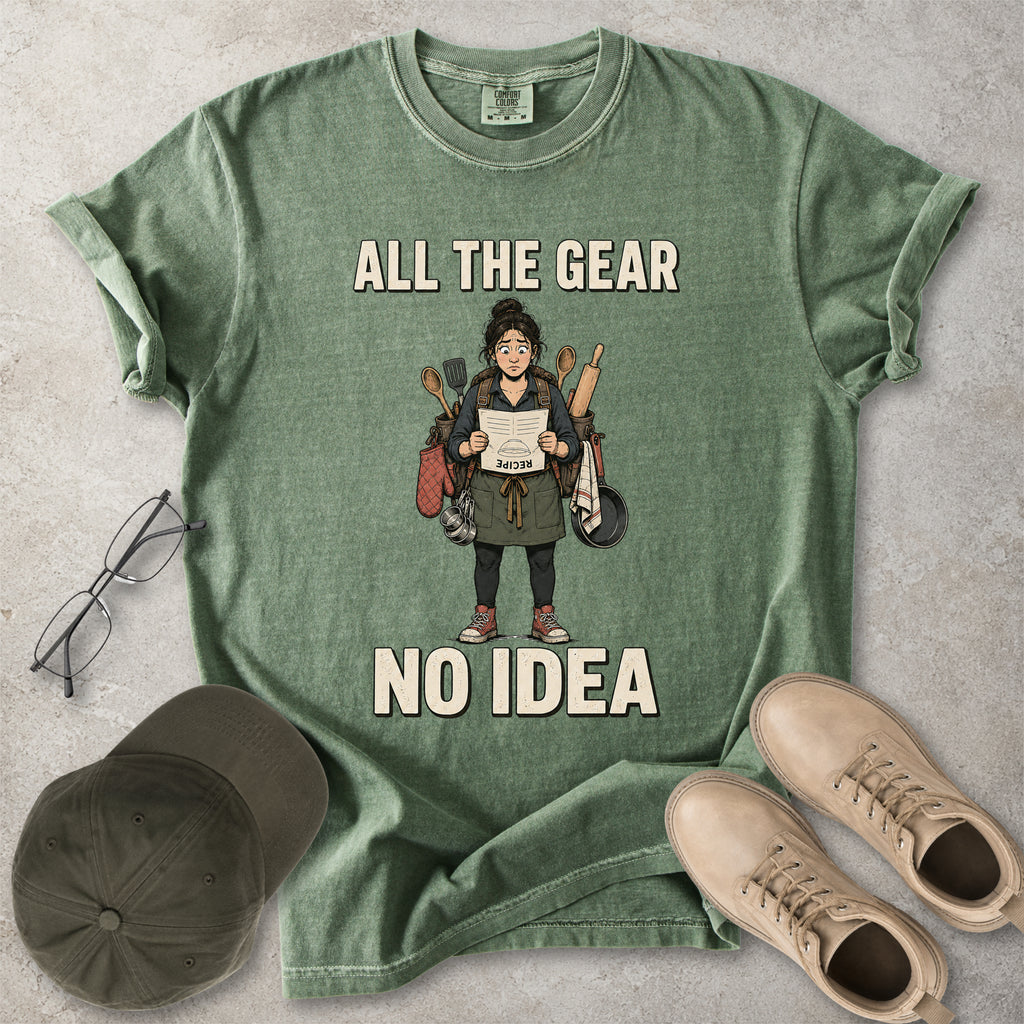 Moss green Comfort Colors 1717 T-shirt with a funny All the Gear No Idea cooking graphic showing a woman holding an upside-down recipe with kitchen utensils.