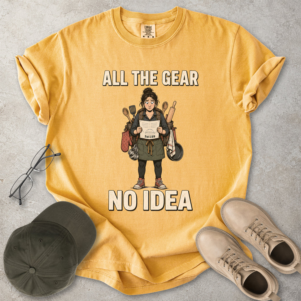 Mustard yellow Comfort Colors 1717 T-shirt with a funny All the Gear No Idea cooking graphic showing a woman holding an upside-down recipe with kitchen utensils.