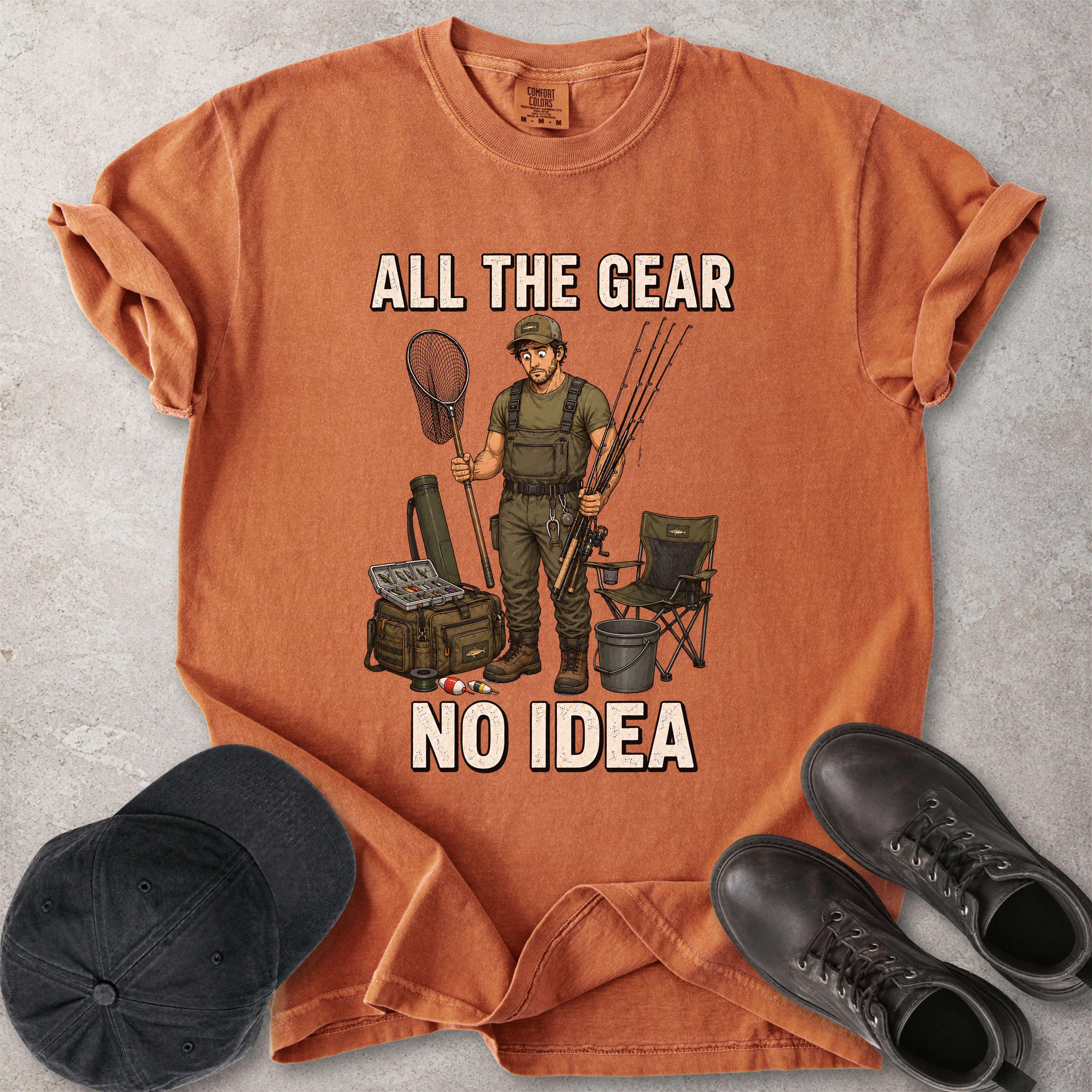 Yam orange Comfort Colors 1717 T-shirt with a funny All the Gear No Idea fishing graphic showing a confused fisherman holding rods and a landing net with fishing gear.