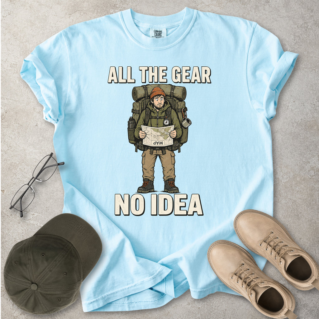 Chambray light blue Comfort Colors 1717 T-shirt with a funny All the Gear No Idea hiking graphic showing a confused hiker holding an upside-down map with a large backpack.