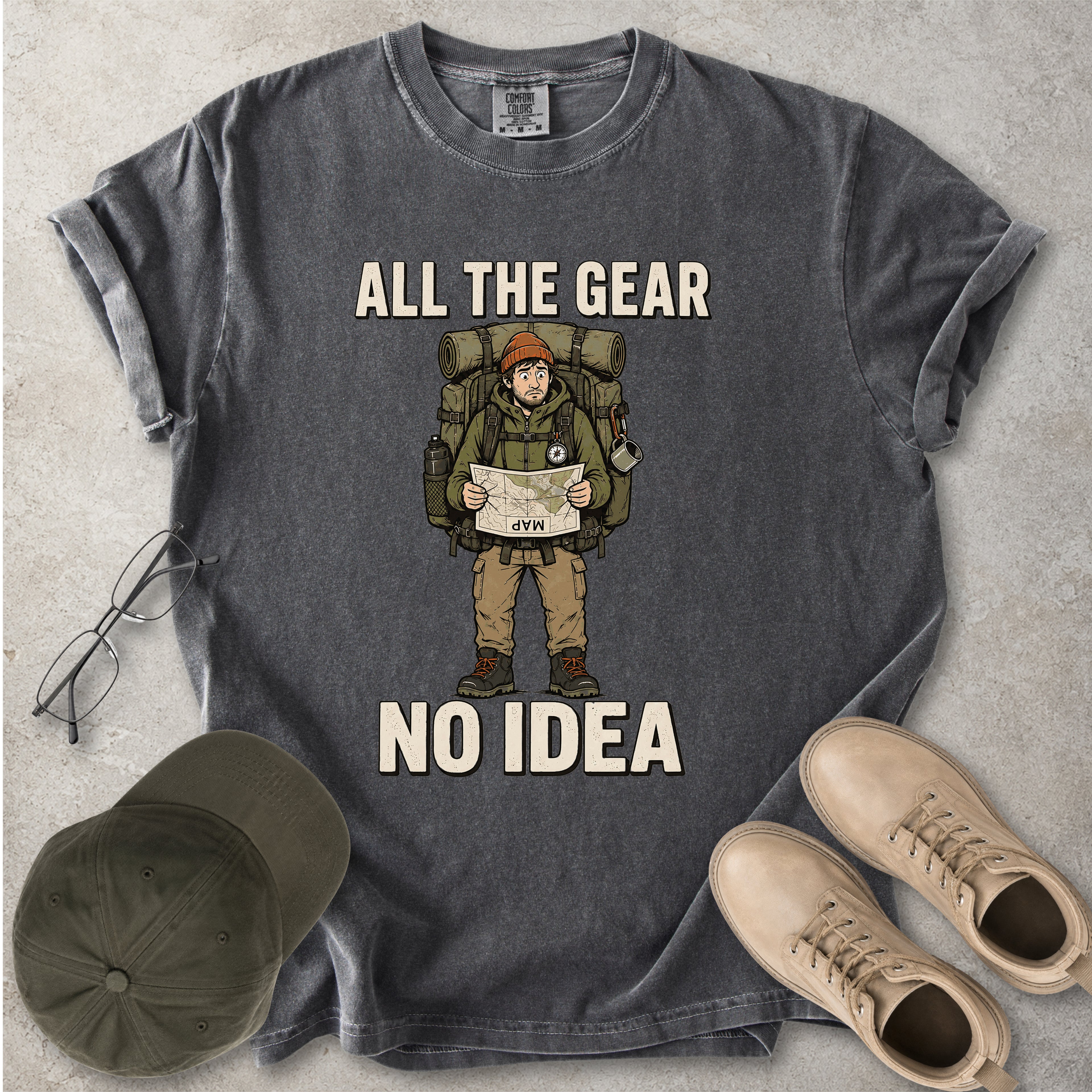 Pepper grey Comfort Colors 1717 T-shirt with a funny All the Gear No Idea hiking graphic showing a confused hiker holding an upside-down map with a large backpack.