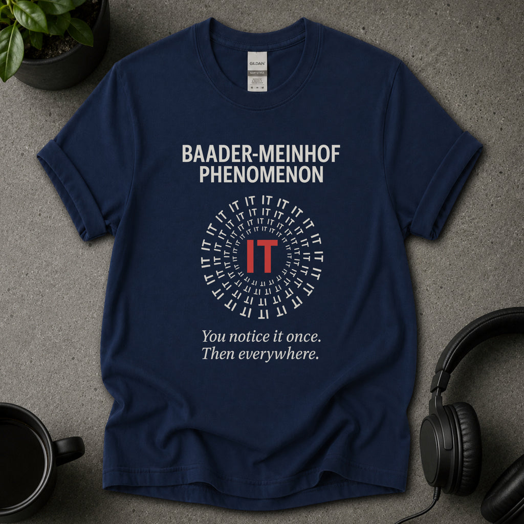 Navy blue t-shirt with 'Baader-Meinhof Phenomenon' text on a gray surface with headphones and a mug.