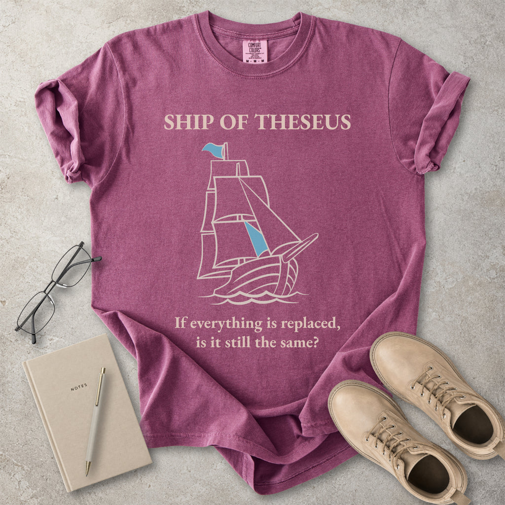 Berry red Comfort Colors graphic T-shirt with Ship of Theseus text, line-art sailing ship and the phrase if everything is replaced is it still the same