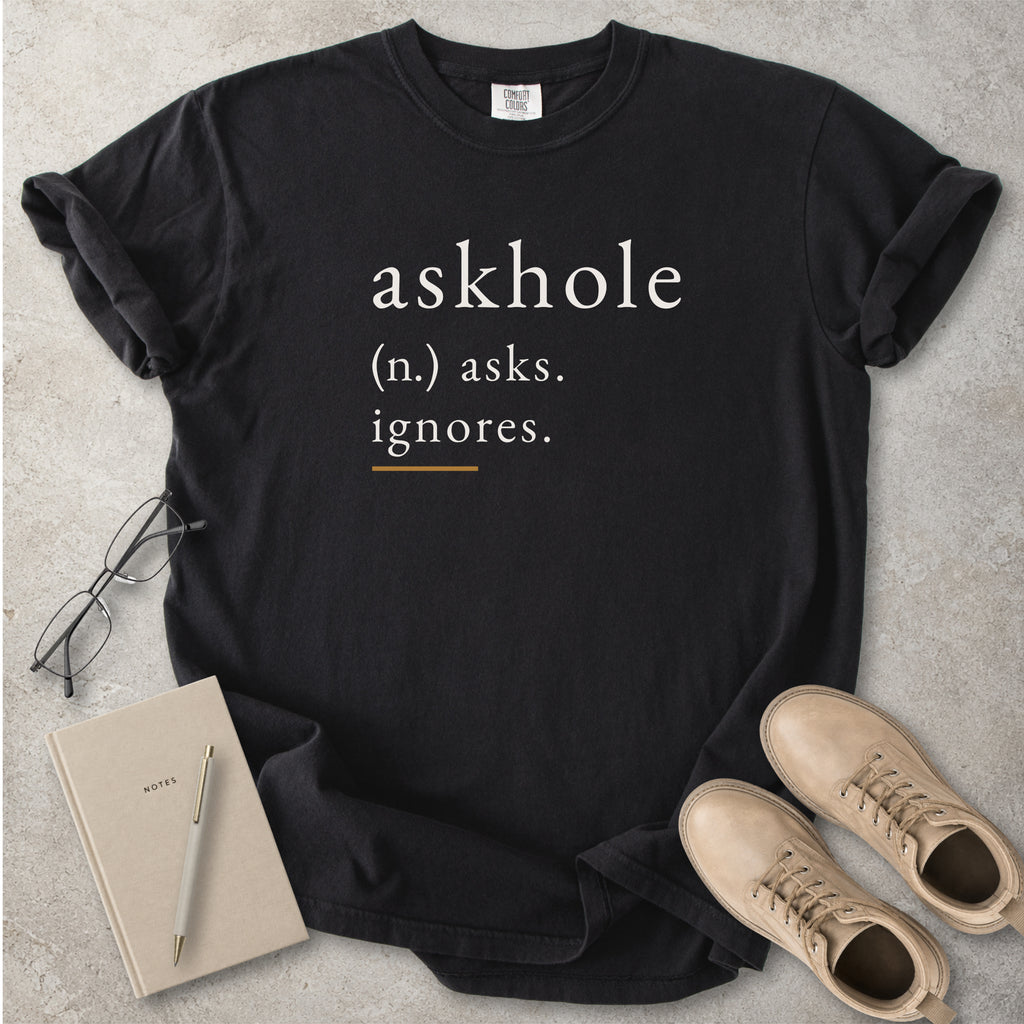 Black Comfort Colors graphic T-shirt with askhole definition text reading asks ignores, styled with notebook, pen, glasses and tan boots