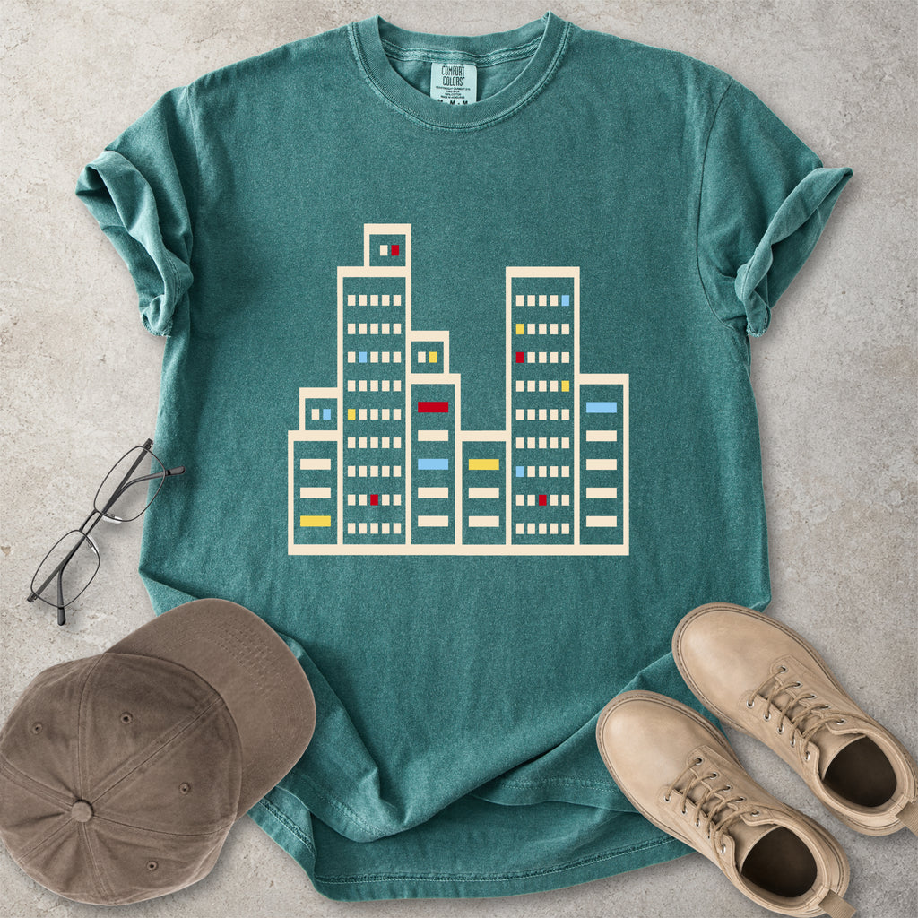 Blue spruce Comfort Colors graphic T-shirt with a minimalist cityscape window design, styled with glasses, cap and tan boots