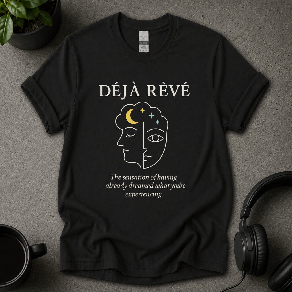 Black t-shirt with 'Déj  Rèvé' design on a gray surface with a cup and headphones.