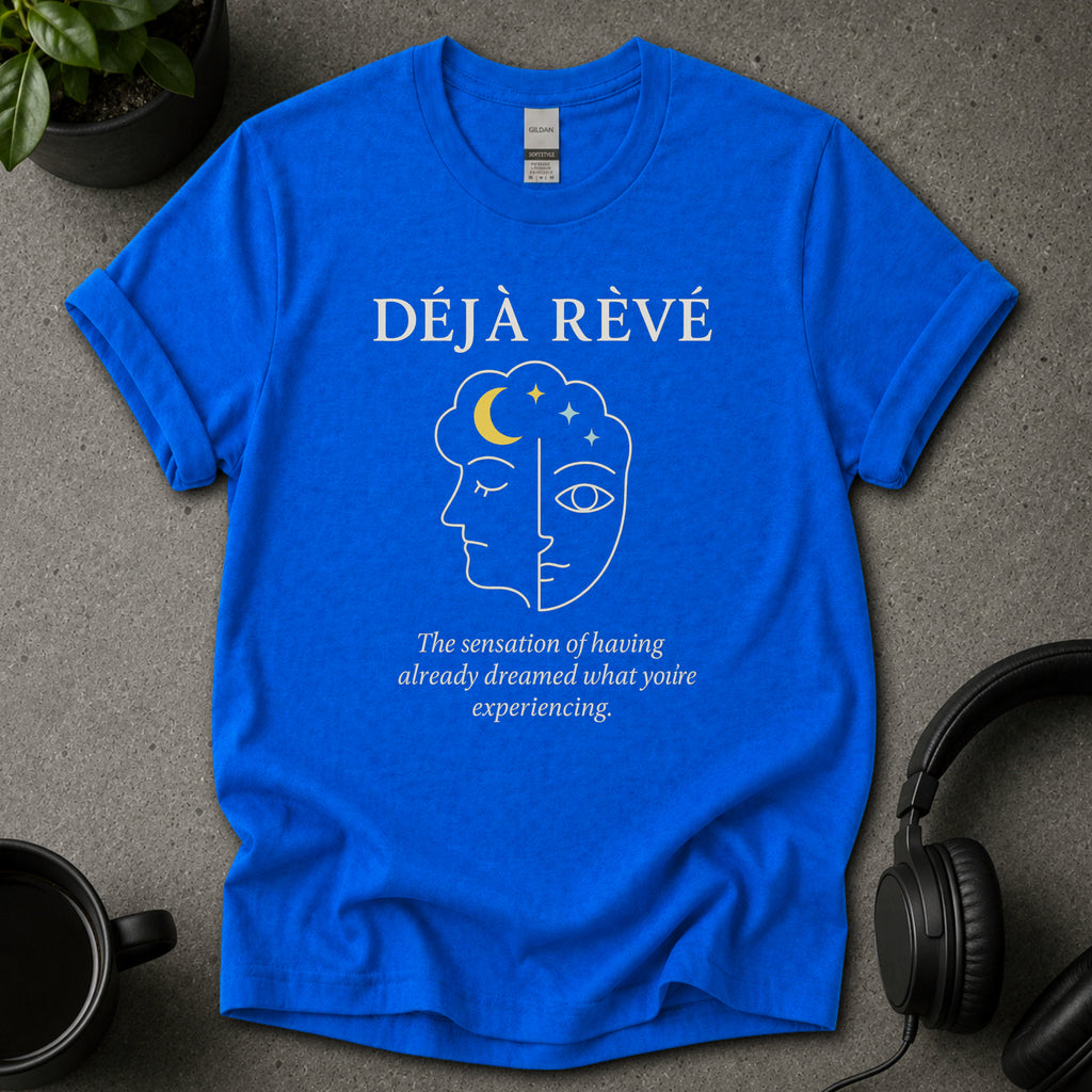 Blue t-shirt with 'Déj  Rèvé' design on a gray surface with headphones and a mug.