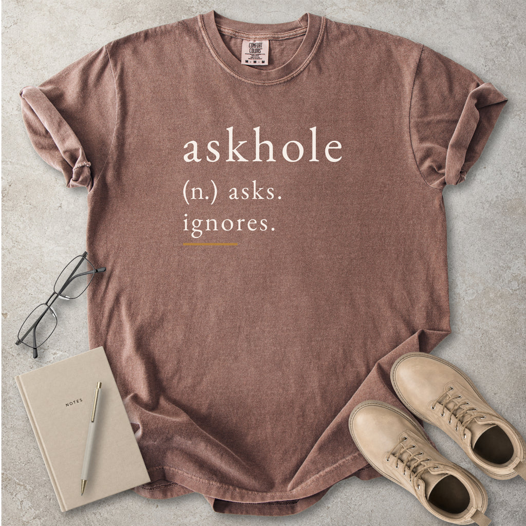 Espresso brown Comfort Colors graphic T-shirt with askhole definition text reading asks ignores, styled with notebook, pen, glasses and tan boots