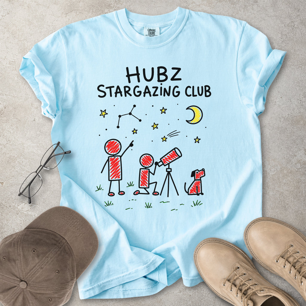 Light blue t-shirt with 'HUBZ Stargazing Club' text and graphics on a concrete surface.
