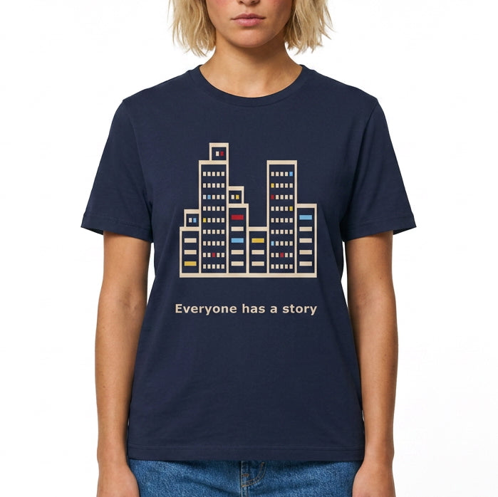 Navy blue t-shirt with cityscape design and 'Everyone has a story' text worn by a person on a white background