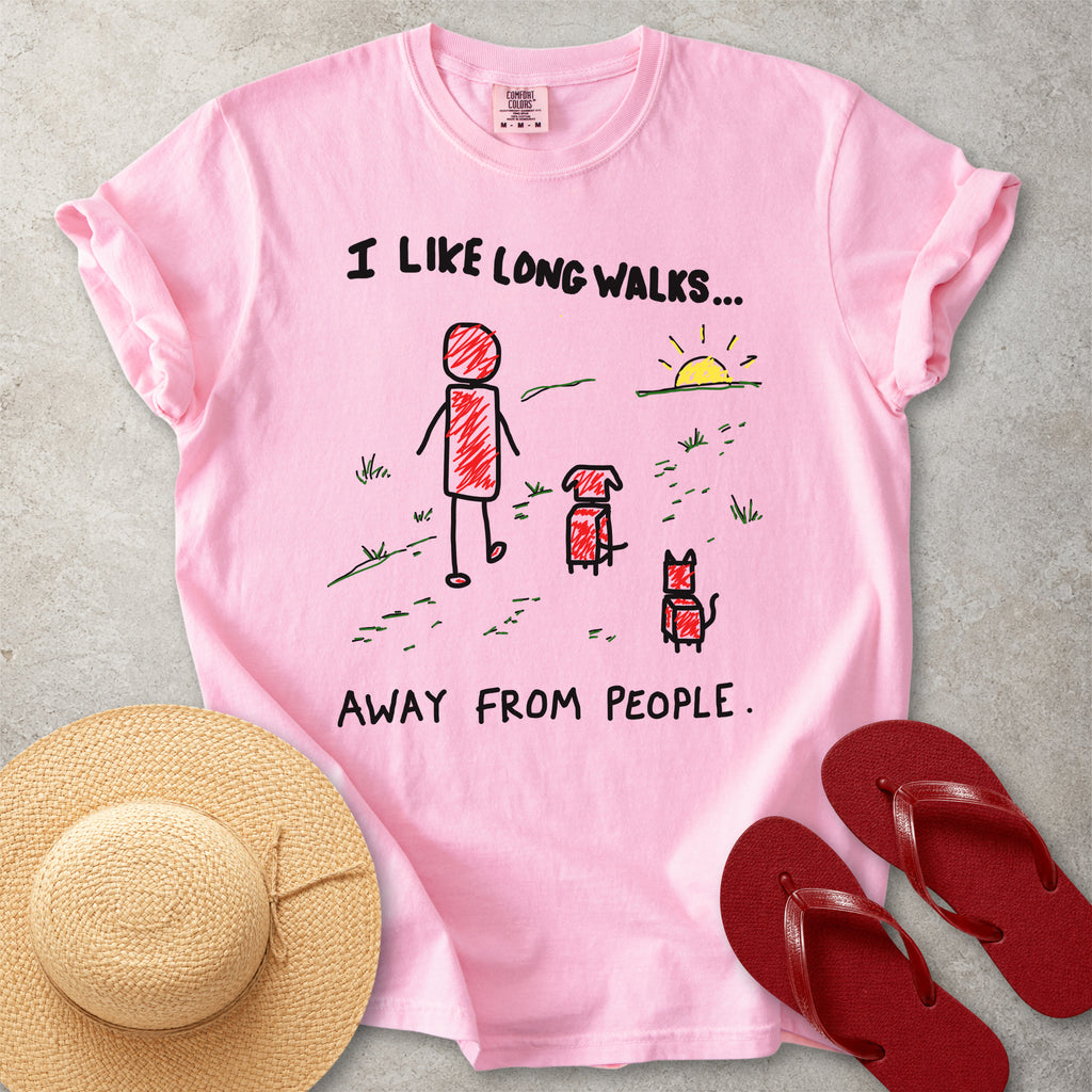 Pink Comfort Colors graphic T-shirt with hand-drawn I like long walks away from people design showing a person walking with a dog and cat, styled with straw hat and red flip flops