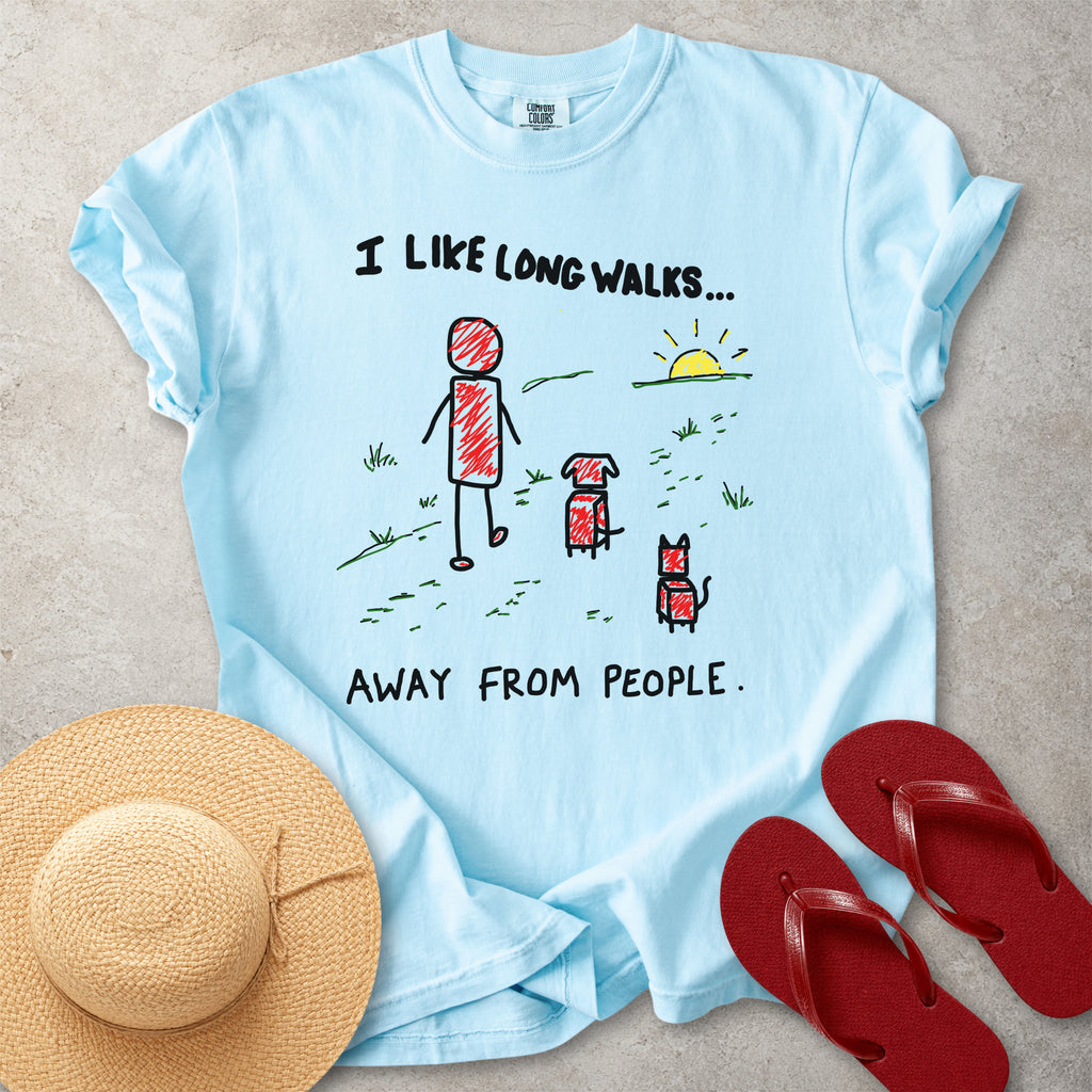 Blue Comfort Colors graphic T-shirt with hand-drawn I like long walks away from people design showing a person walking with a dog and cat, styled with straw hat and red flip flops