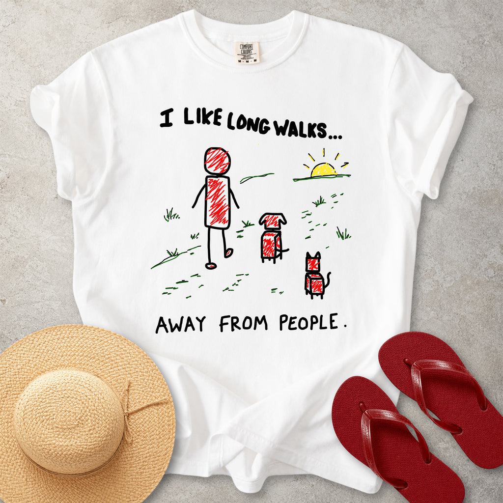 White Comfort Colors graphic T-shirt with hand-drawn I like long walks away from people design showing a person walking with a dog and cat, styled with straw hat and red flip flops