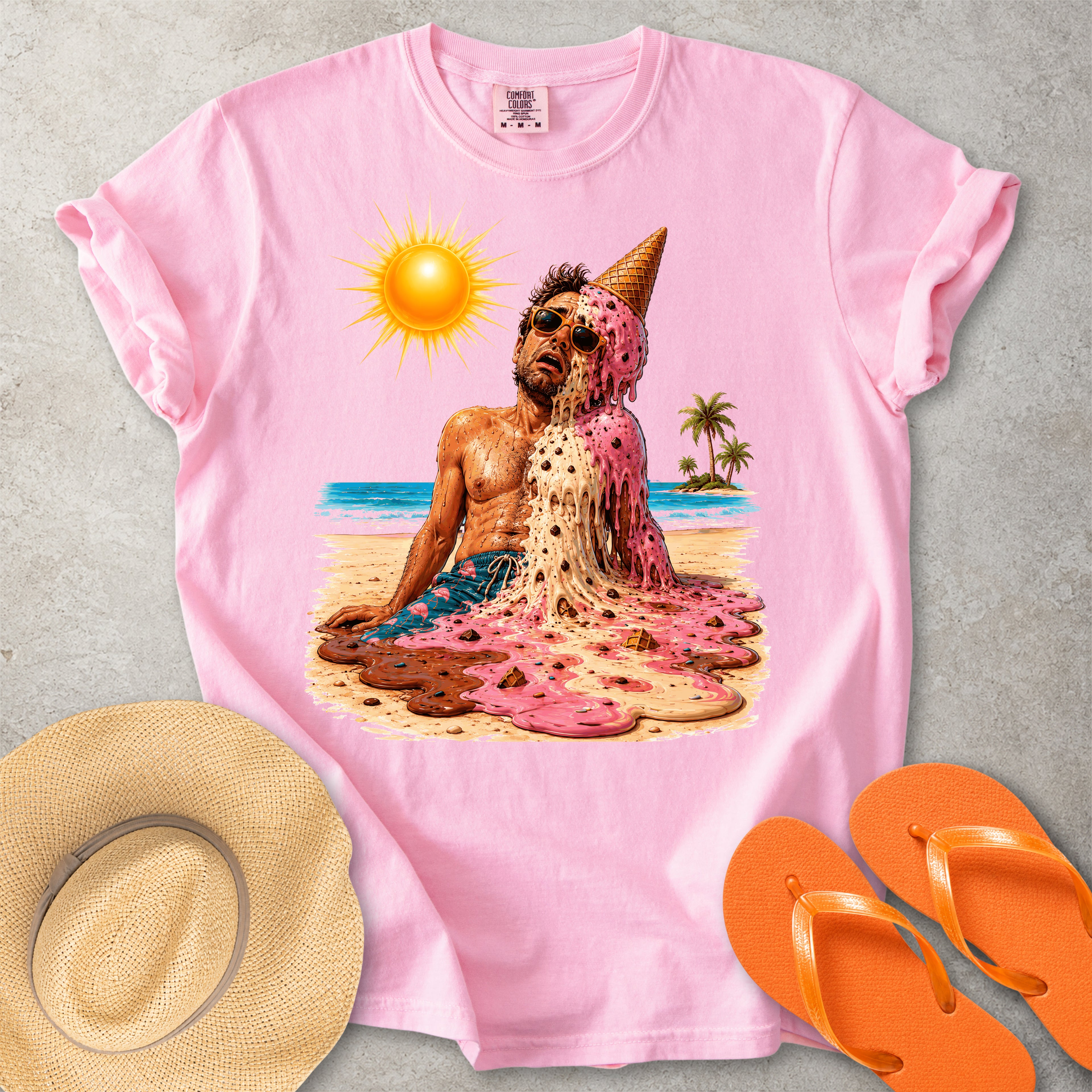 Pink Comfort Colors graphic T-shirt with a melting ice cream man on a sunny beach, styled with straw hat and orange flip flops
