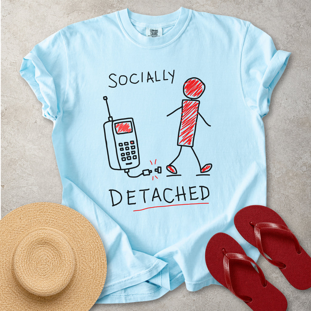 Light blue Comfort Colors graphic T-shirt with hand-drawn socially detached design showing a person walking away from an unplugged phone, styled with straw hat and red flip flops