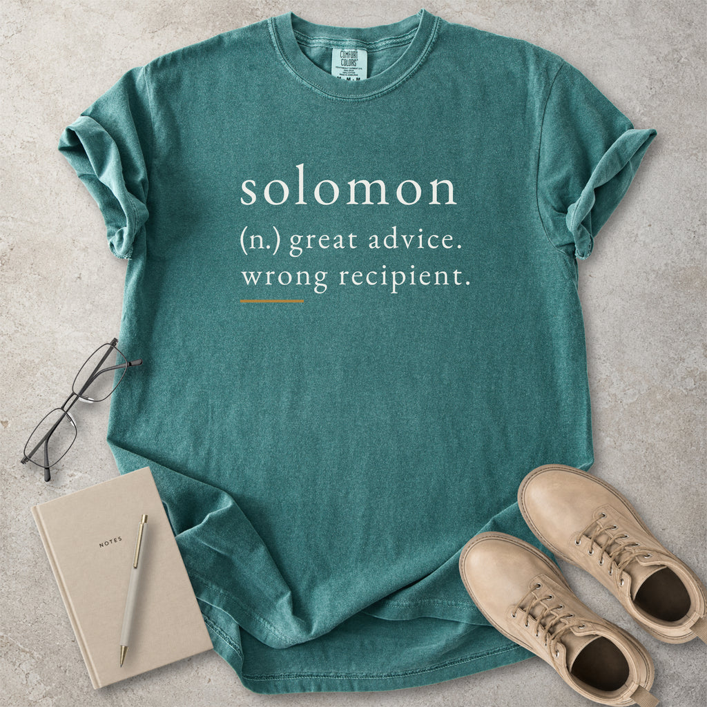 Green Comfort Colors graphic T-shirt with Solomon definition text reading great advice wrong recipient, styled with notebook, pen and tan boots