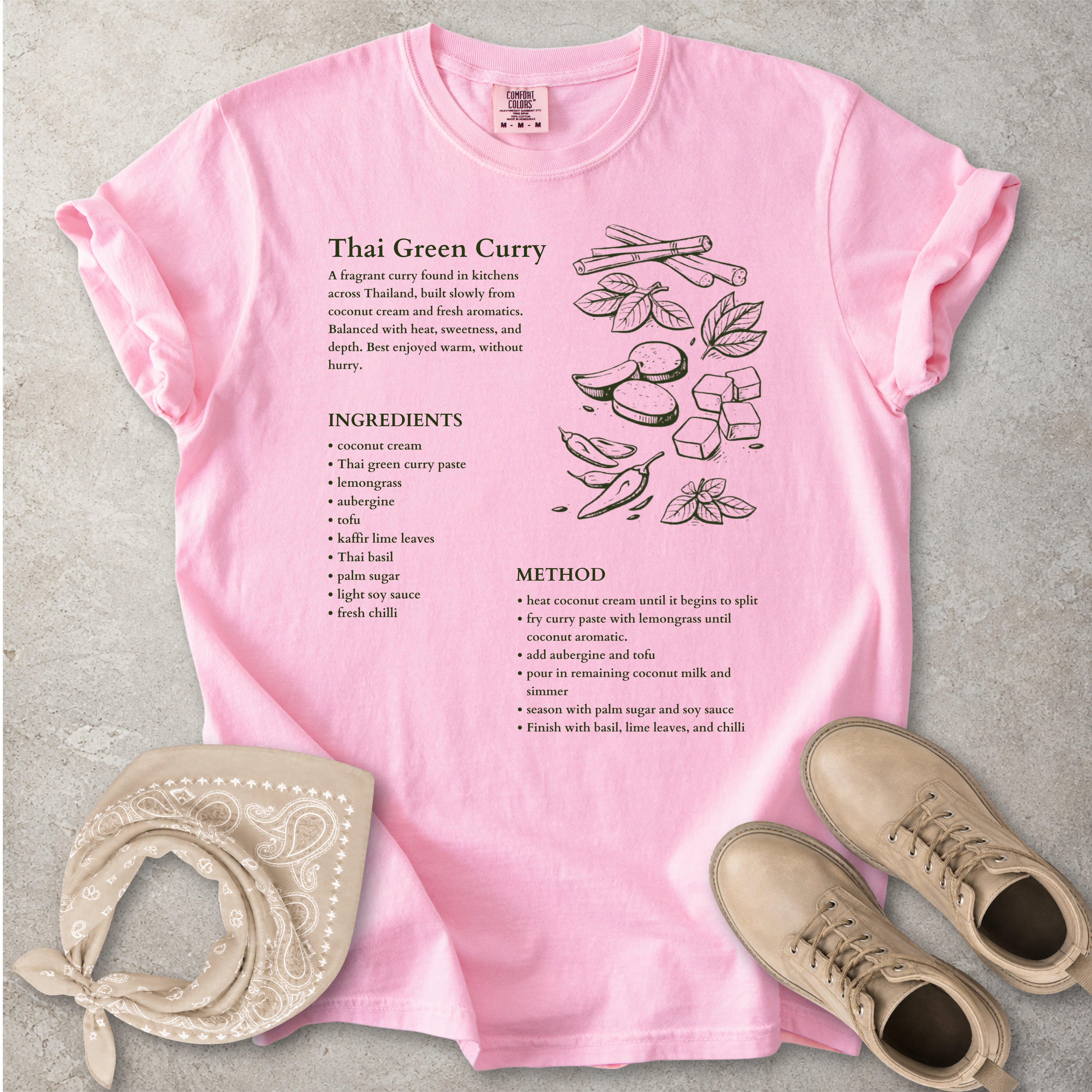 Pink Comfort Colors graphic T-shirt with Thai green curry recipe text, ingredients list, method and food illustration, styled with tan bandana and boots