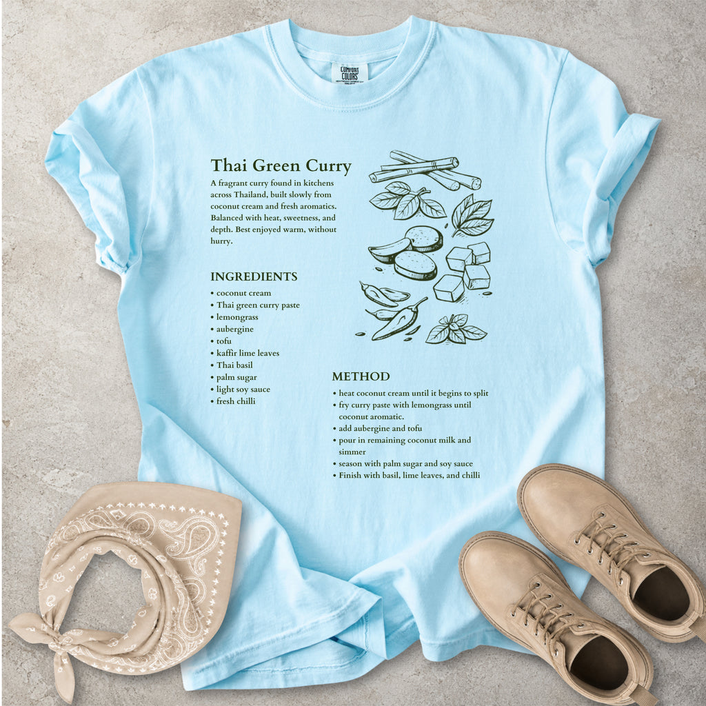 Light blue Comfort Colors graphic T-shirt with Thai green curry recipe text, ingredients list, method and food illustration, styled with tan bandana and boots