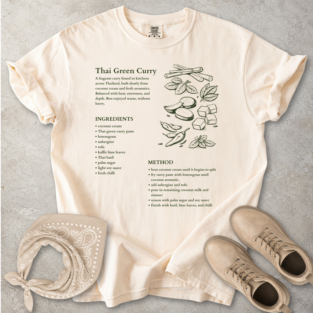 Beige Comfort Colors graphic T-shirt with Thai green curry recipe text, ingredients list, method and food illustration, styled with tan bandana and boots