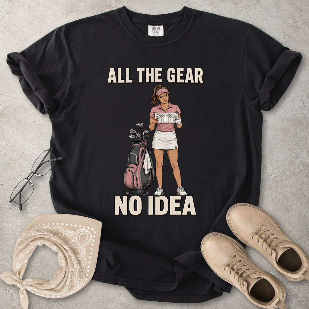 Black Comfort Colors 1717 T-shirt with a funny All the Gear No Idea golf graphic showing a woman golfer holding a scorecard beside a golf bag.