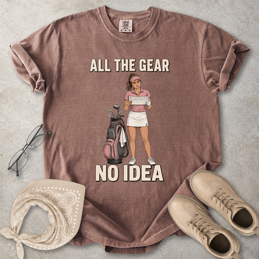 Espresso brown Comfort Colors 1717 T-shirt with a funny All the Gear No Idea golf graphic showing a woman golfer holding a scorecard beside a golf bag.