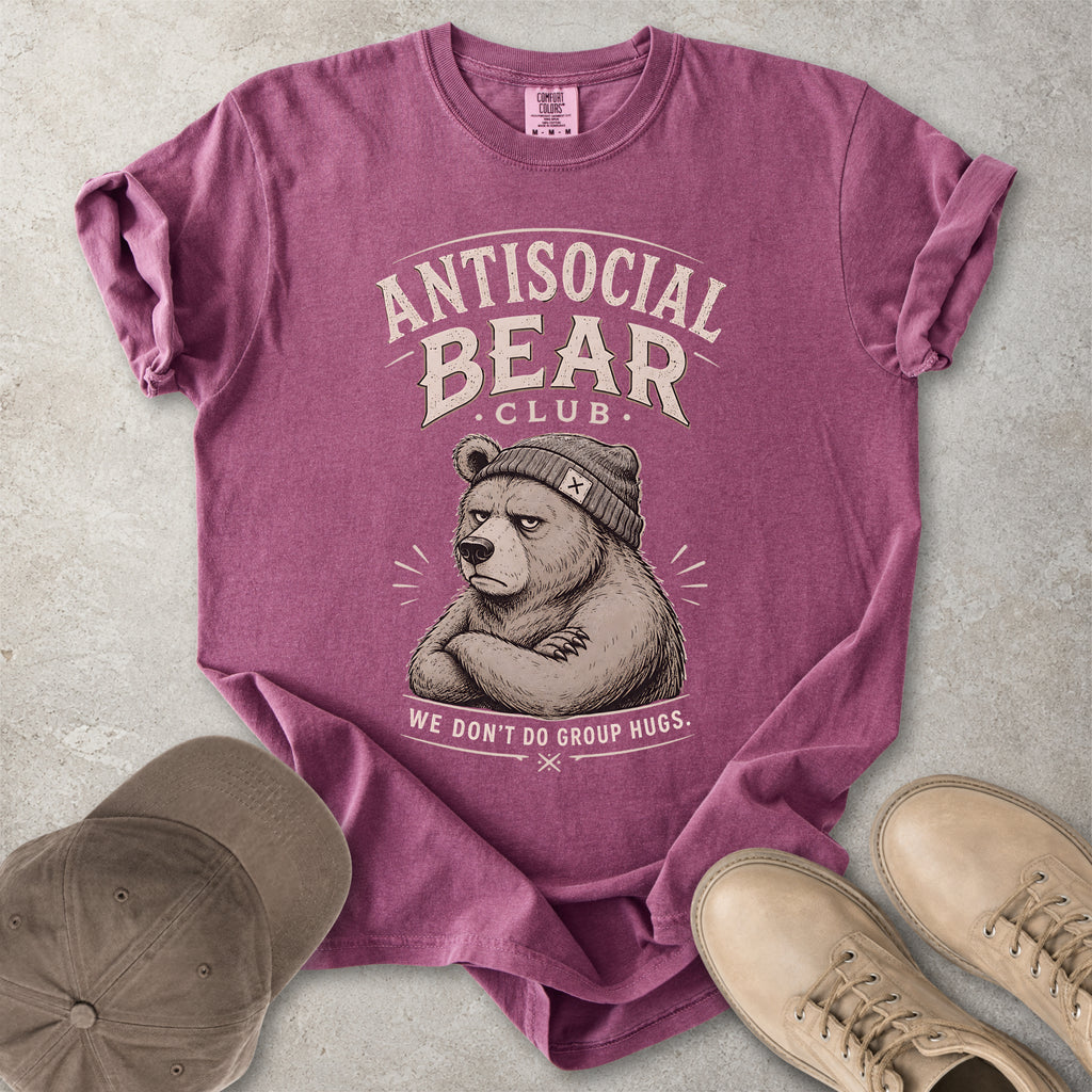 Purple t-shirt with 'Antisocial Bear Club' graphic on a concrete surface with a cap and shoes.