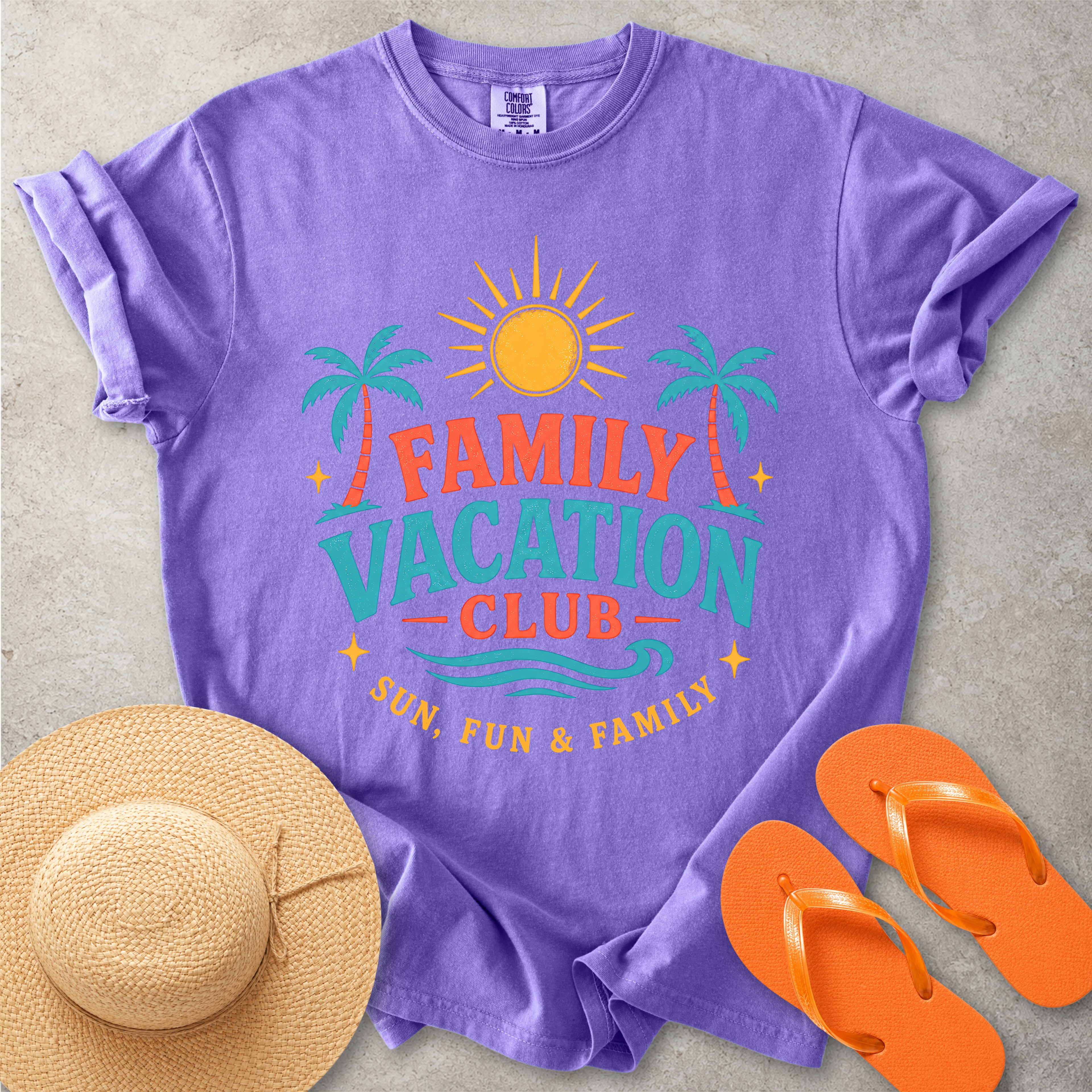 Purple t-shirt with 'Family Vacation Club' design, straw hat, and orange flip-flops on a gray surface