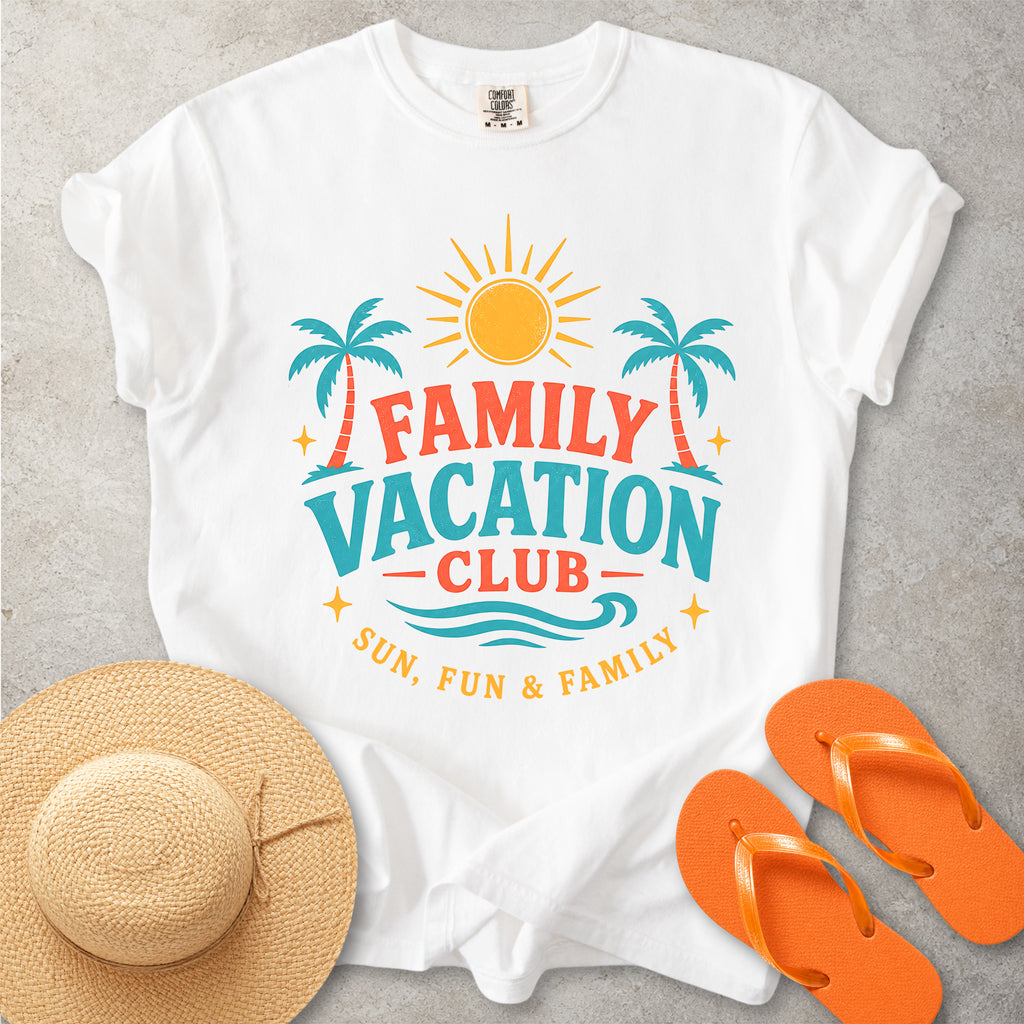 White t-shirt with 'Family Vacation Club' design, straw hat, and orange flip-flops on a gray surface