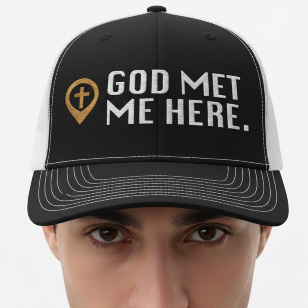 Model wearing the God Met Me Here Trucker Cap in Black / White — god met me here, testimony, Richardson 112 christian trucker cap