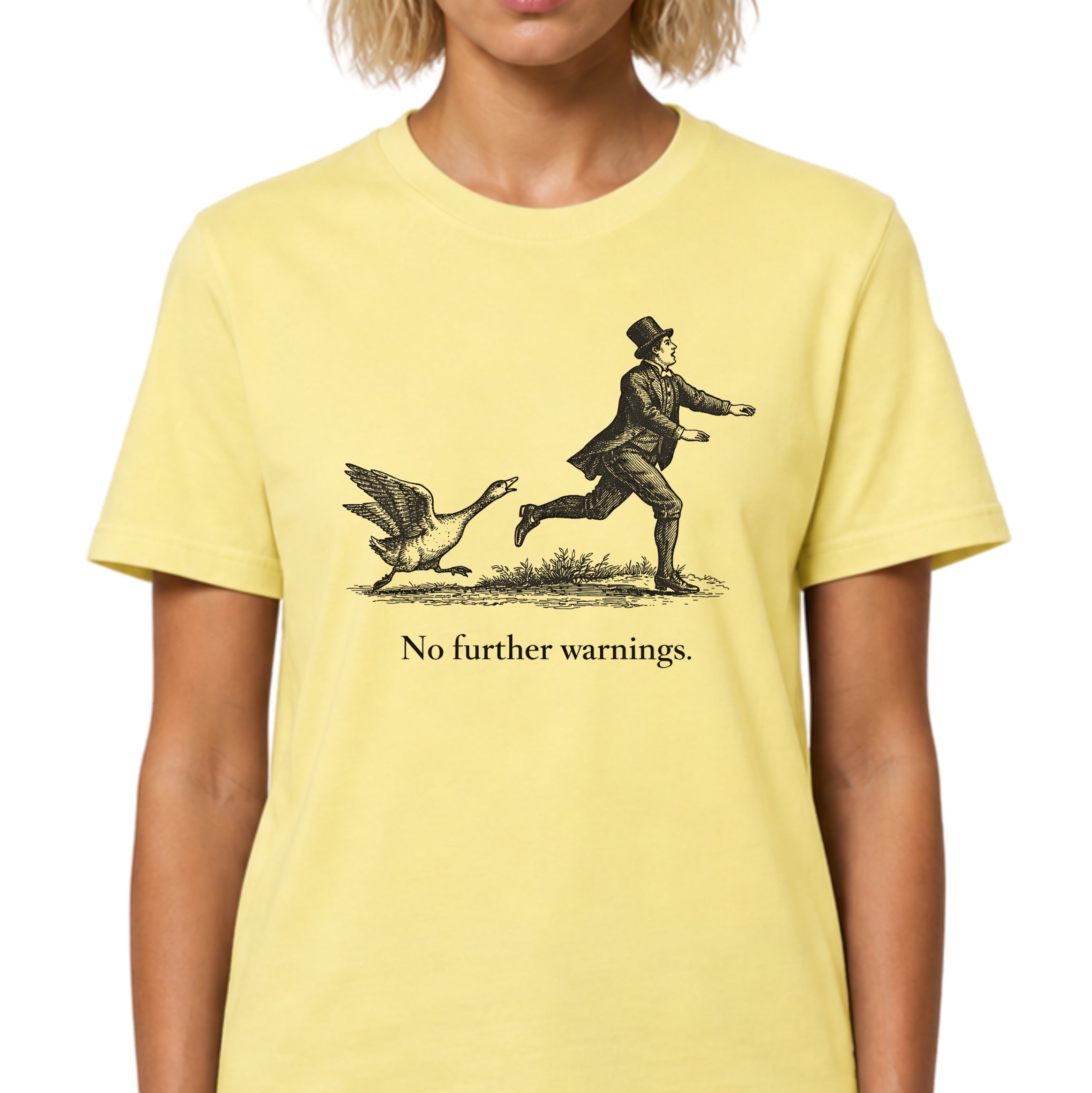 Person wearing a yellow t-shirt with a graphic of a person chasing a duck and text 'No further warnings.'