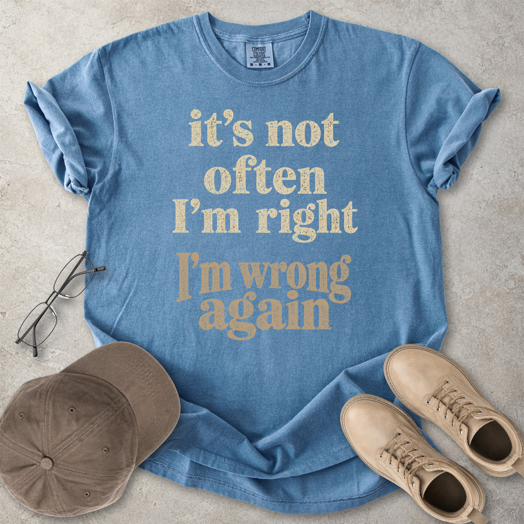 Blue jean Comfort Colors graphic T-shirt with beige text reading it’s not often I’m right I’m wrong again, styled with a cap and black boots