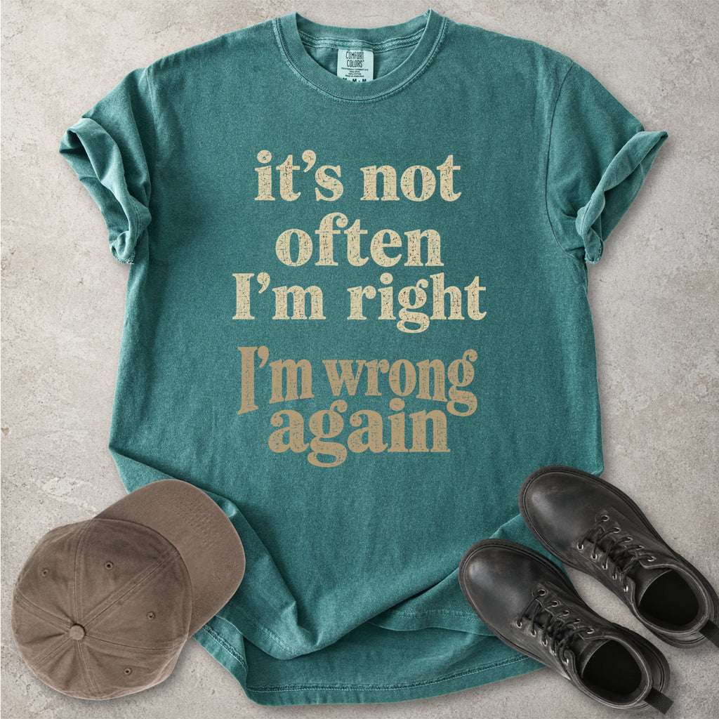 Blue spruce Comfort Colors graphic T-shirt with beige text reading it’s not often I’m right I’m wrong again, styled with a cap and black boots