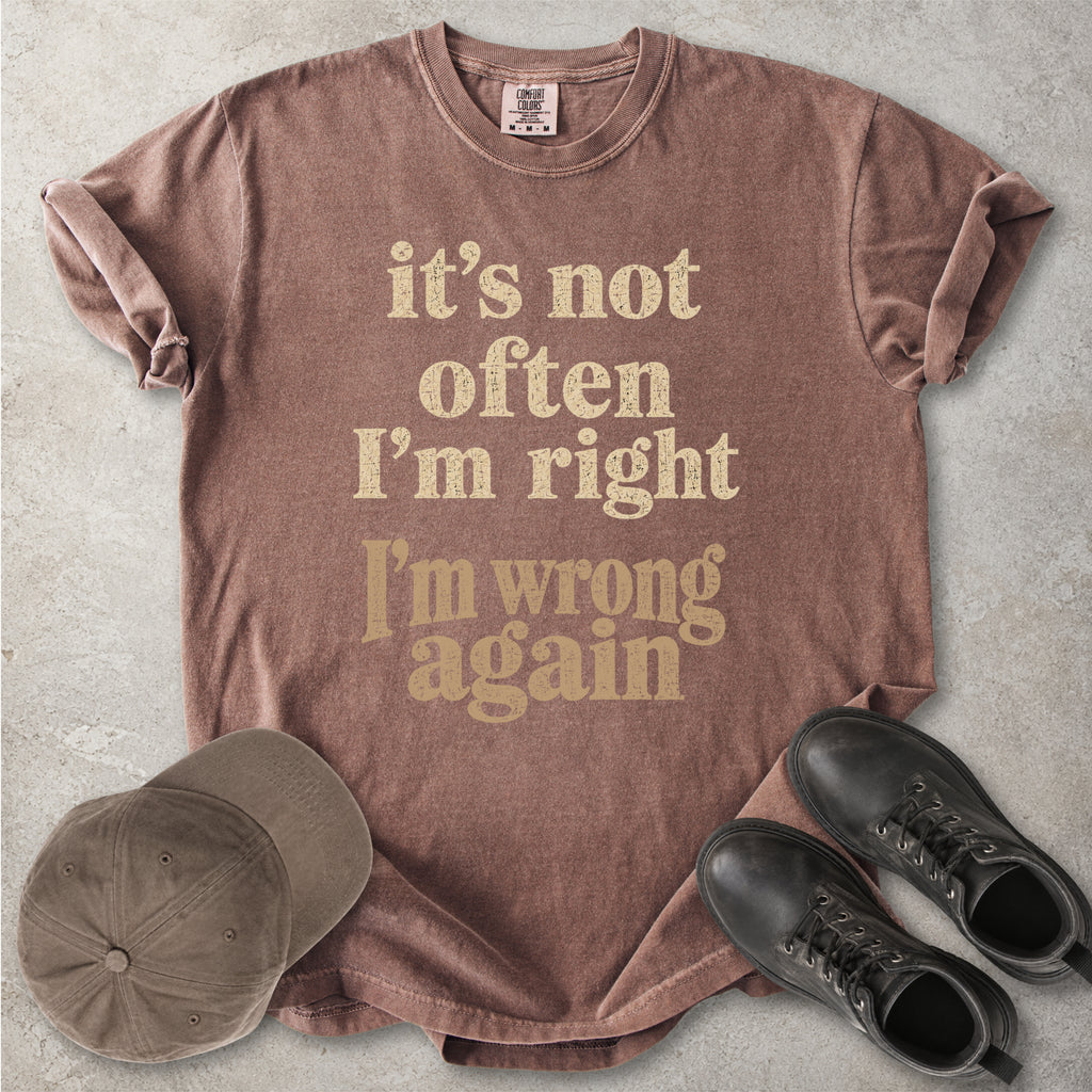 Espresso brown Comfort Colors graphic T-shirt with beige text reading it’s not often I’m right I’m wrong again, styled with a cap and black boots