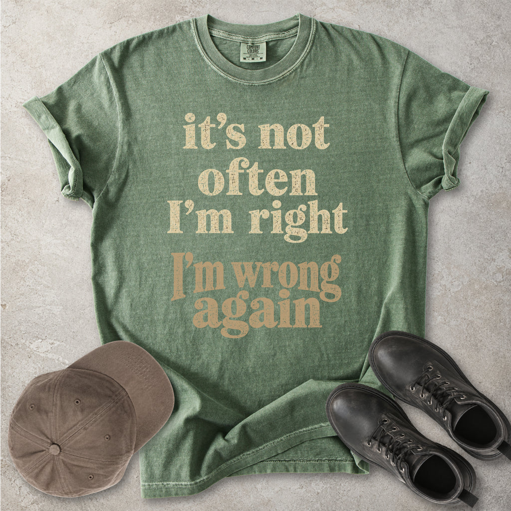 Moss Comfort Colors graphic T-shirt with beige text reading it’s not often I’m right I’m wrong again, styled with a cap and black boots