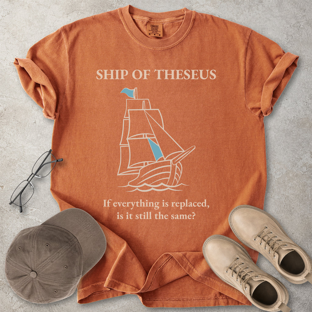 Orange yam Comfort Colors graphic T-shirt with Ship of Theseus text, line-art sailing ship and the phrase if everything is replaced is it still the same