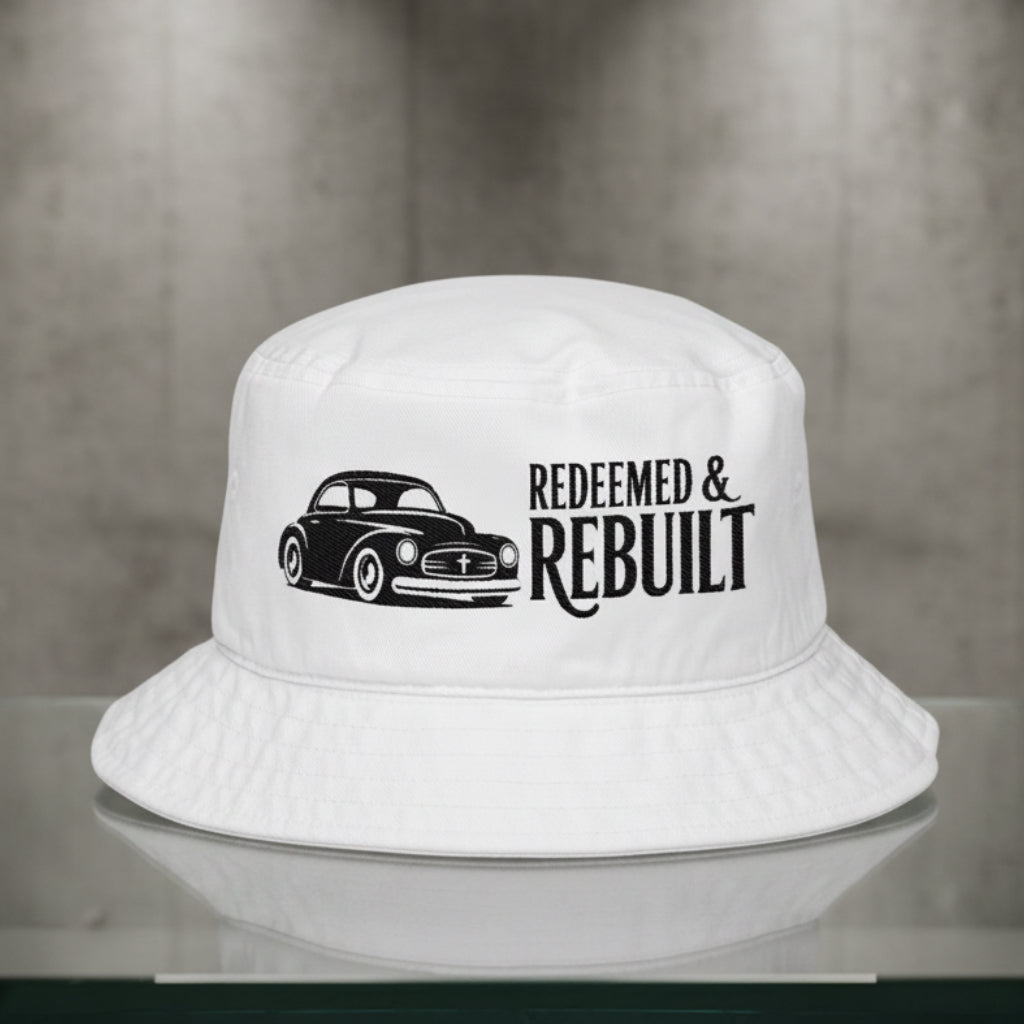 A white bucket hat featuring a black graphic of a classic car and the text 'REDEEMED & REBUILT' printed on the front, set against a plain white background.