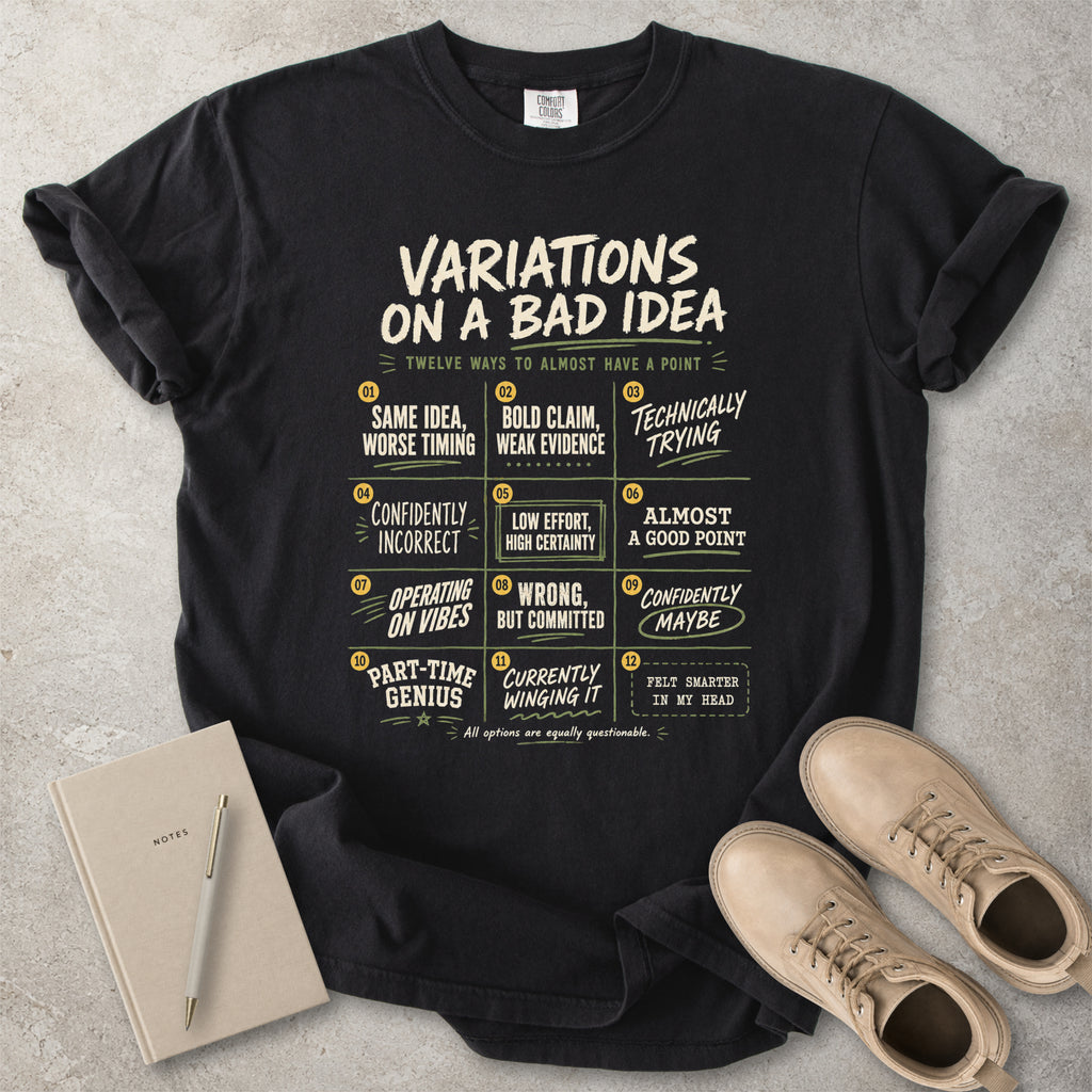 Black Comfort Colors graphic T-shirt with Variations On A Bad Idea decision chart design, styled with coffee, notebook, pen and black boots