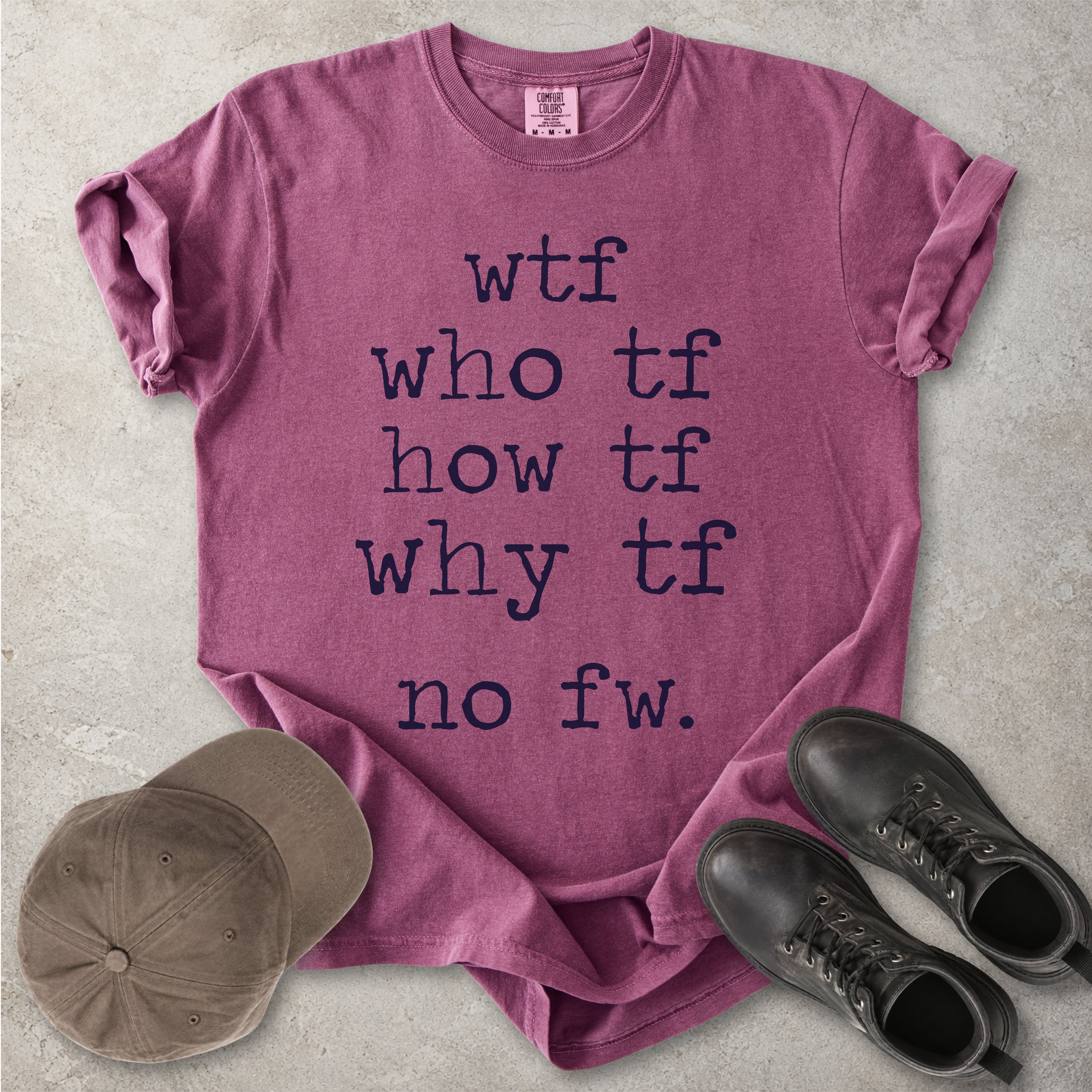 Berry red Comfort Colors graphic T-shirt with grey text reading wtf, who tf, how tf, why tf and no fw, styled with a brown cap and black boots