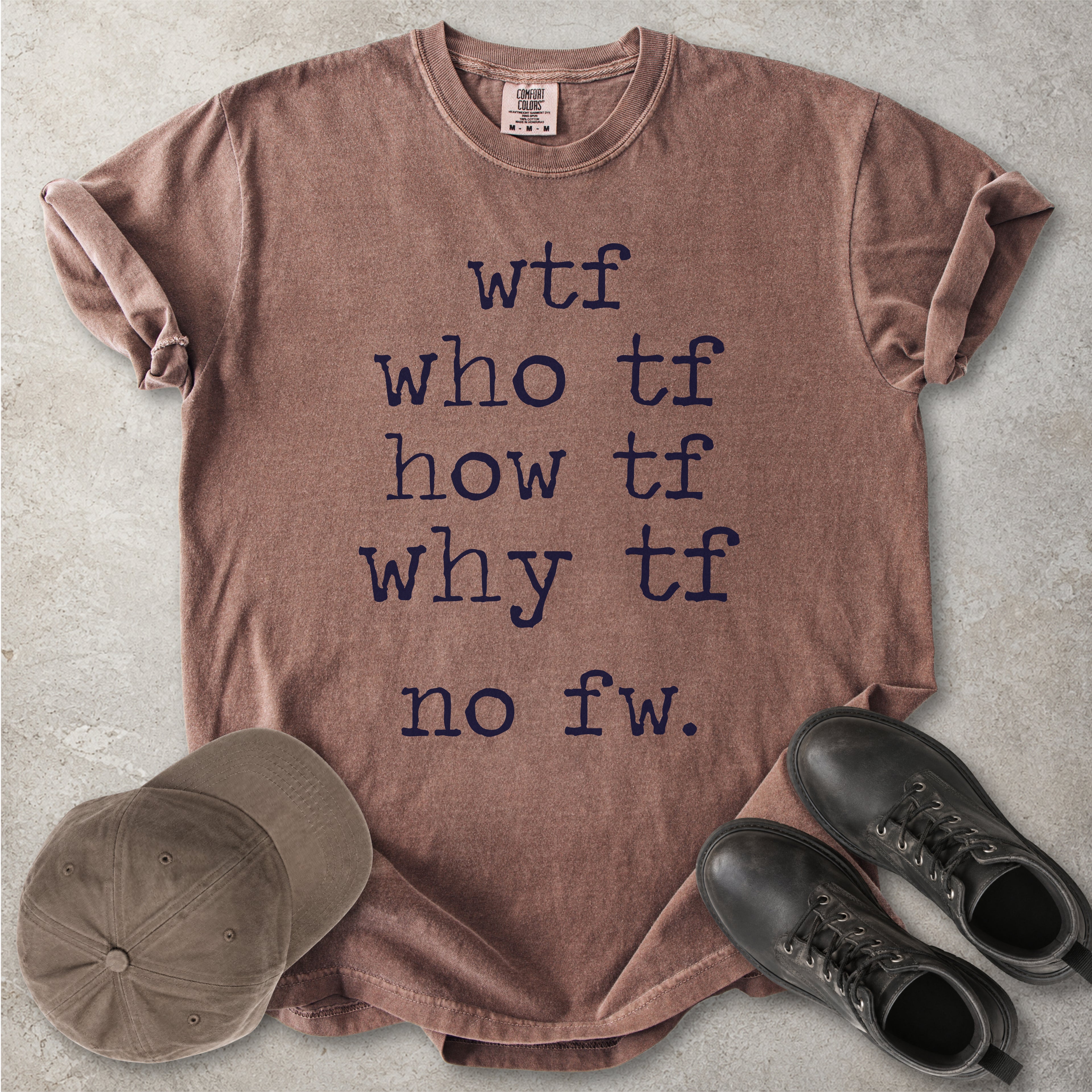 Brown Comfort Colors graphic T-shirt with grey text reading wtf, who tf, how tf, why tf and no fw, styled with a brown cap and black boots