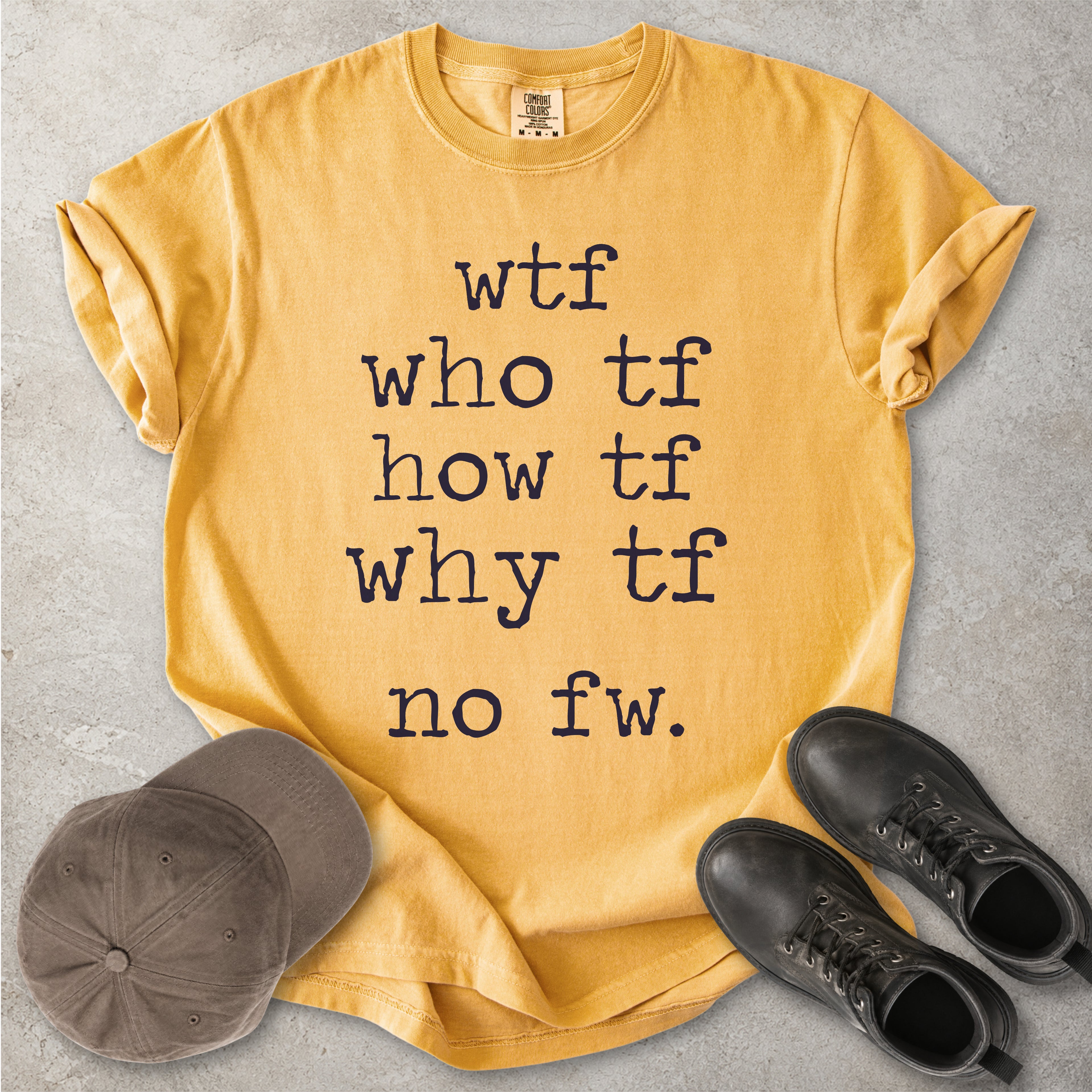 Yellow Comfort Colors graphic T-shirt with grey text reading wtf, who tf, how tf, why tf and no fw, styled with a brown cap and black boots